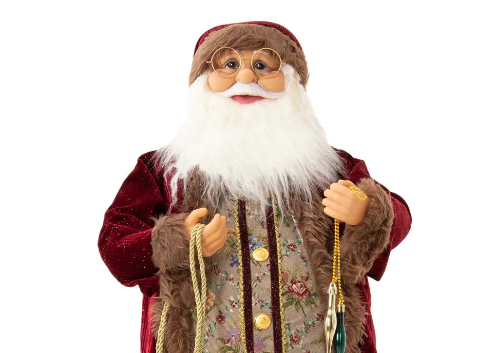 A large Santa Figurine in red velvet coat with green sack from EZ Livings Christams range.Closeup of detail on coat.