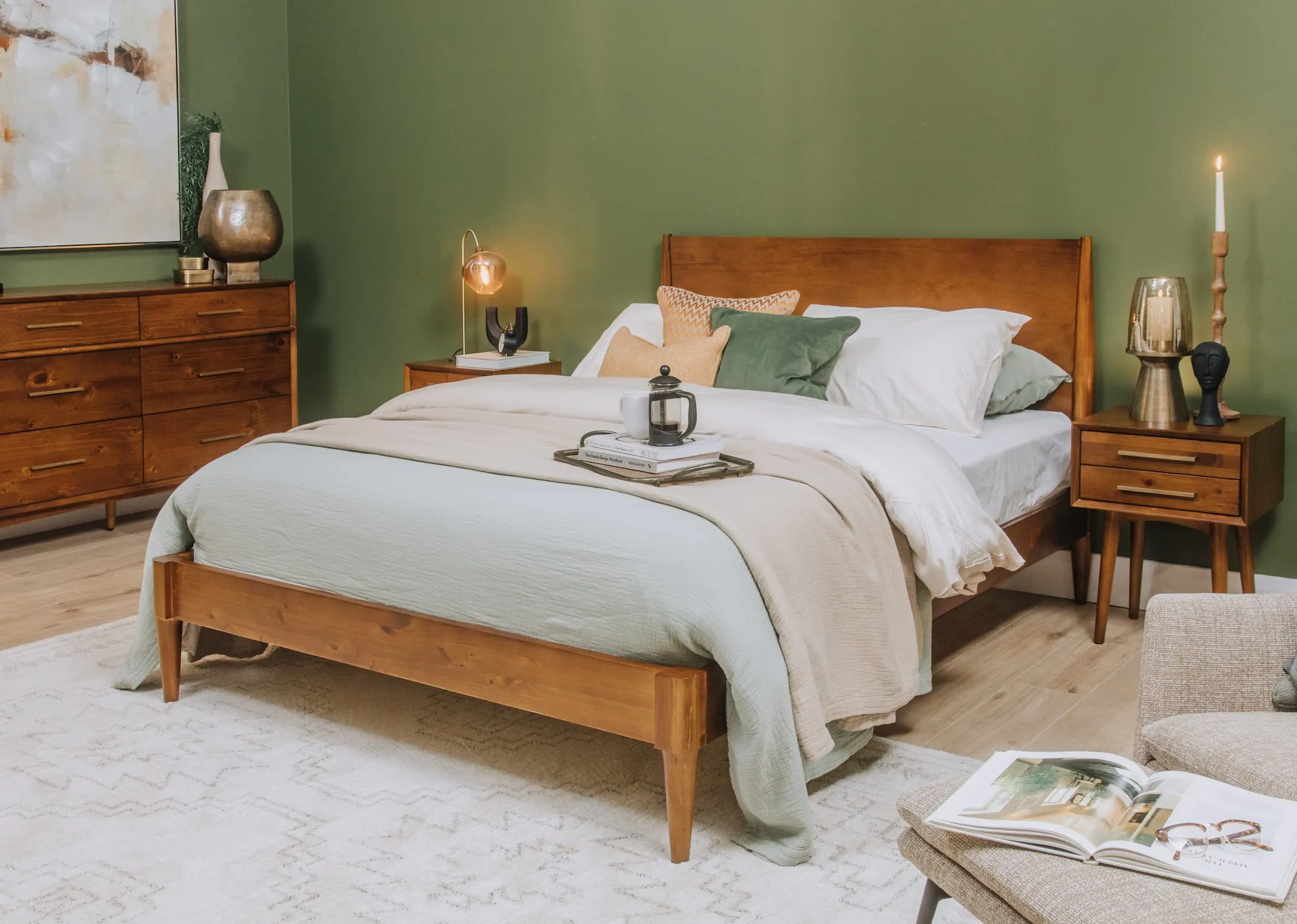 A lifestyle image of the Leya Bedframe with matching chest & locker with green wall and brass accessories.