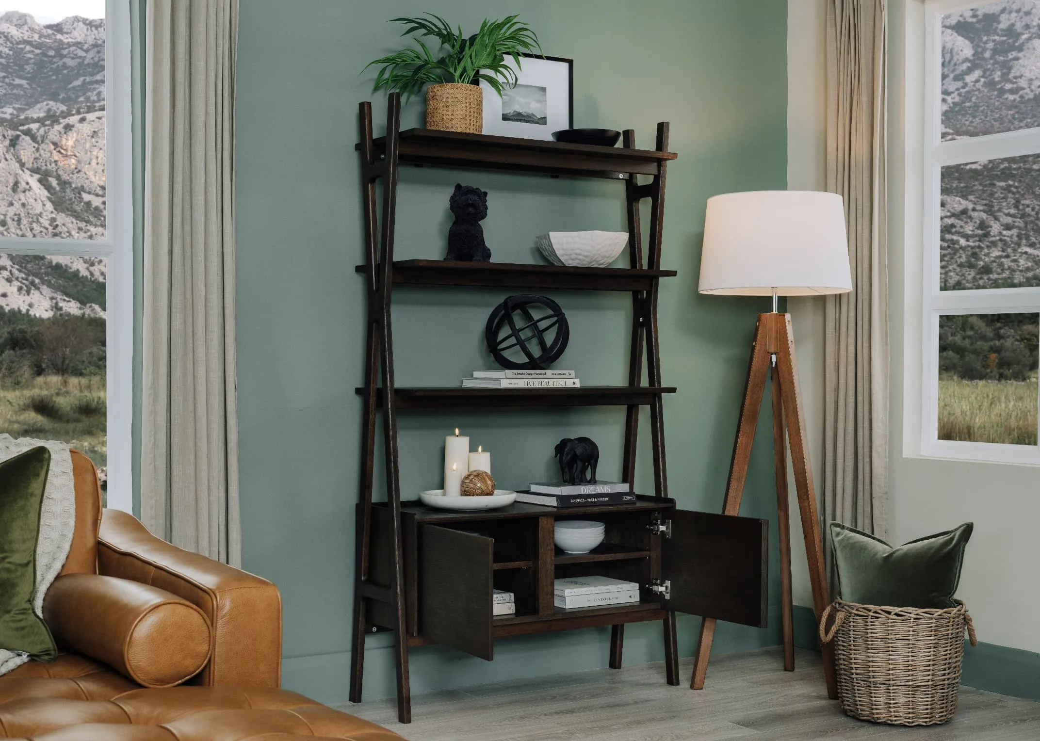 A lifestyle image of the Lura tripod floor lamp with Milton shelving unit with accessories.