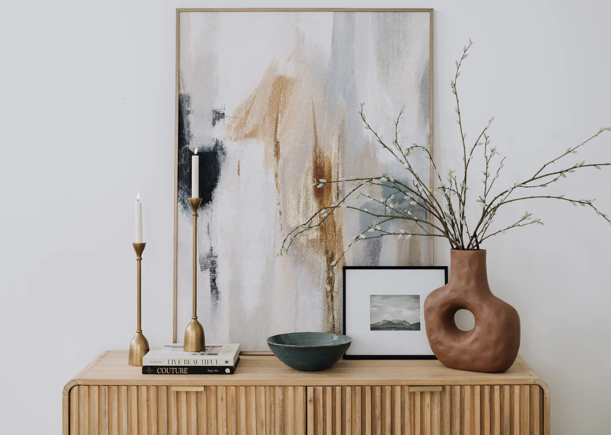 A lifestyle image of the Milo dresser with PAsur candleholders and Terrcotta vase.