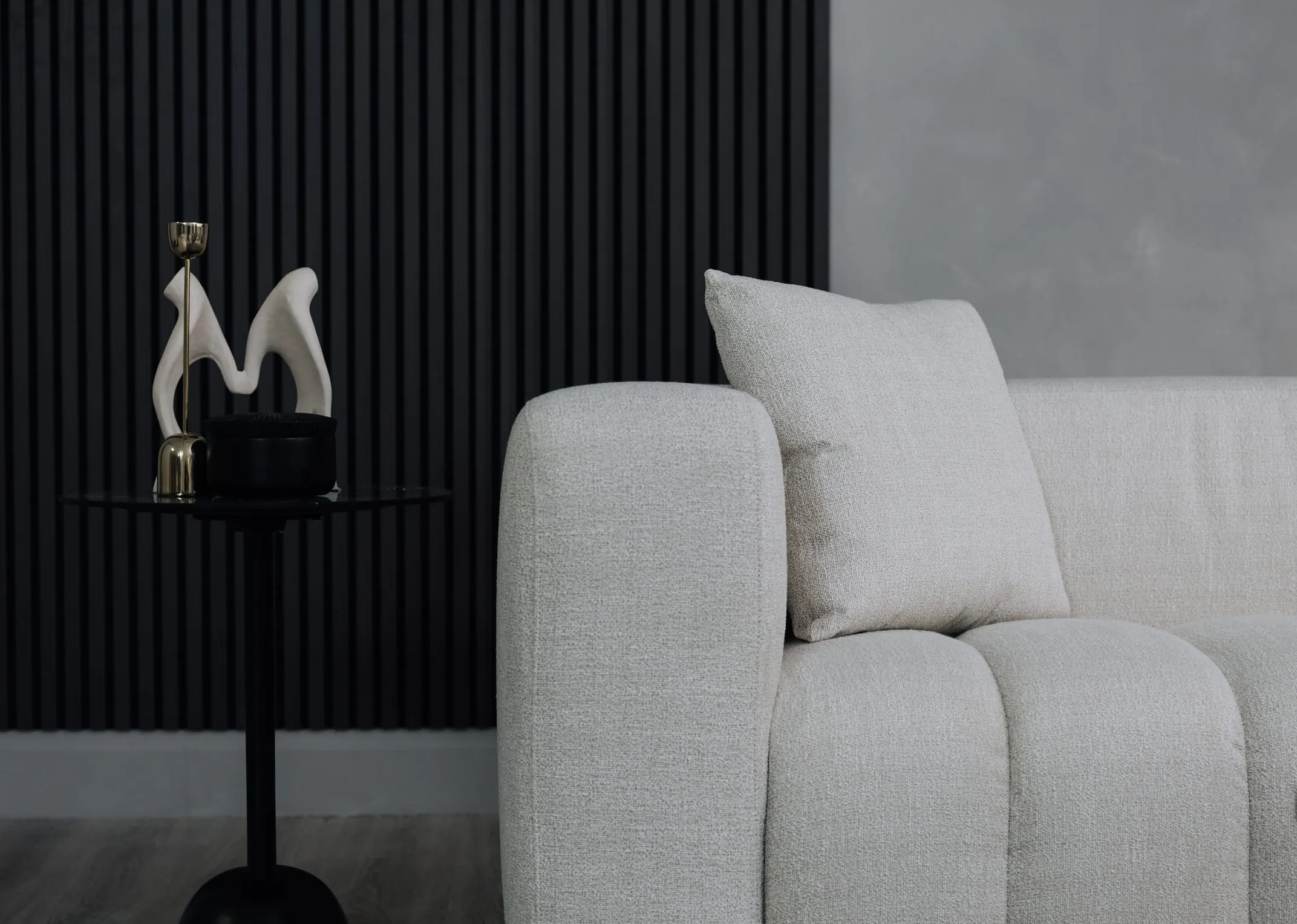 A lifestyle image of the Brandon sofa with massimo side table with Hand sculpture.