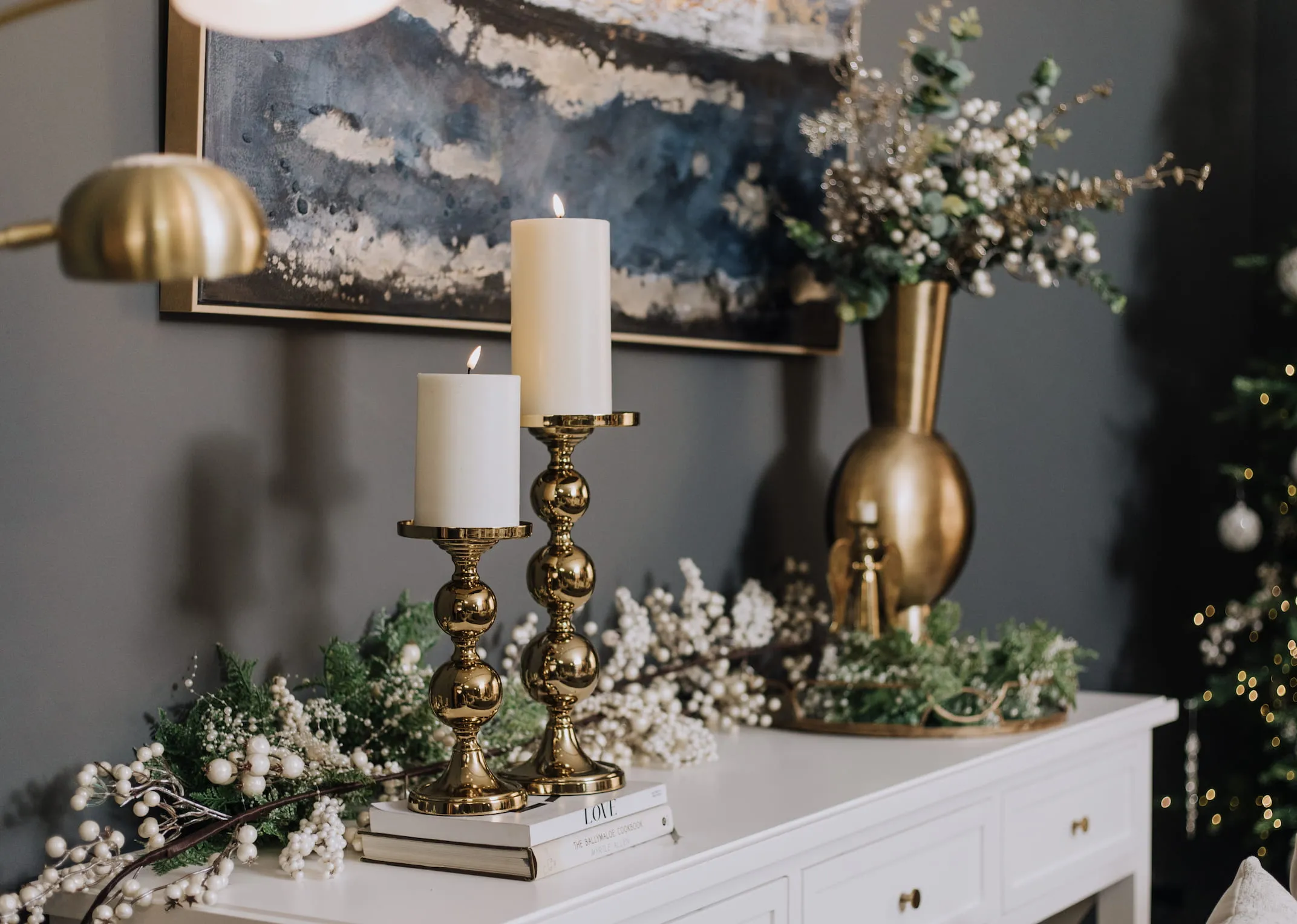 A lifestyle image of the Hampton Console table with Gold Pillar Candle holders with kavandu vase.