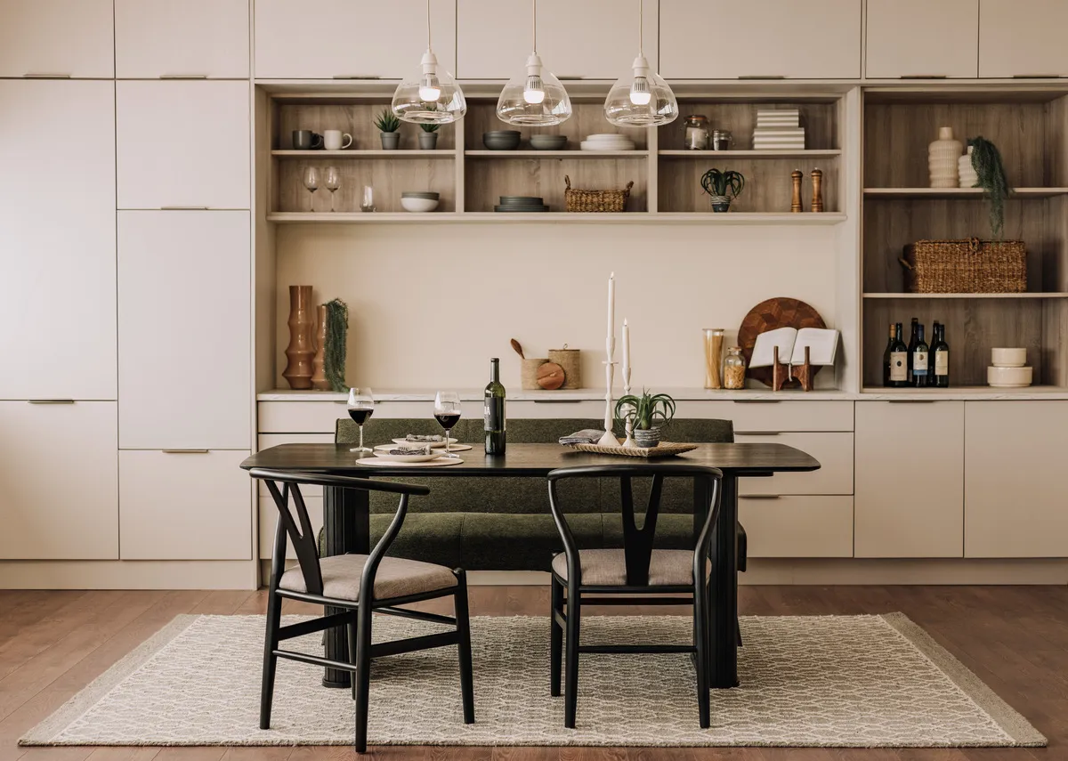 A lifestyle image of the Nola black oak dining table with wishbone dining chairs and Bisho pendant light in a kitchen setting.