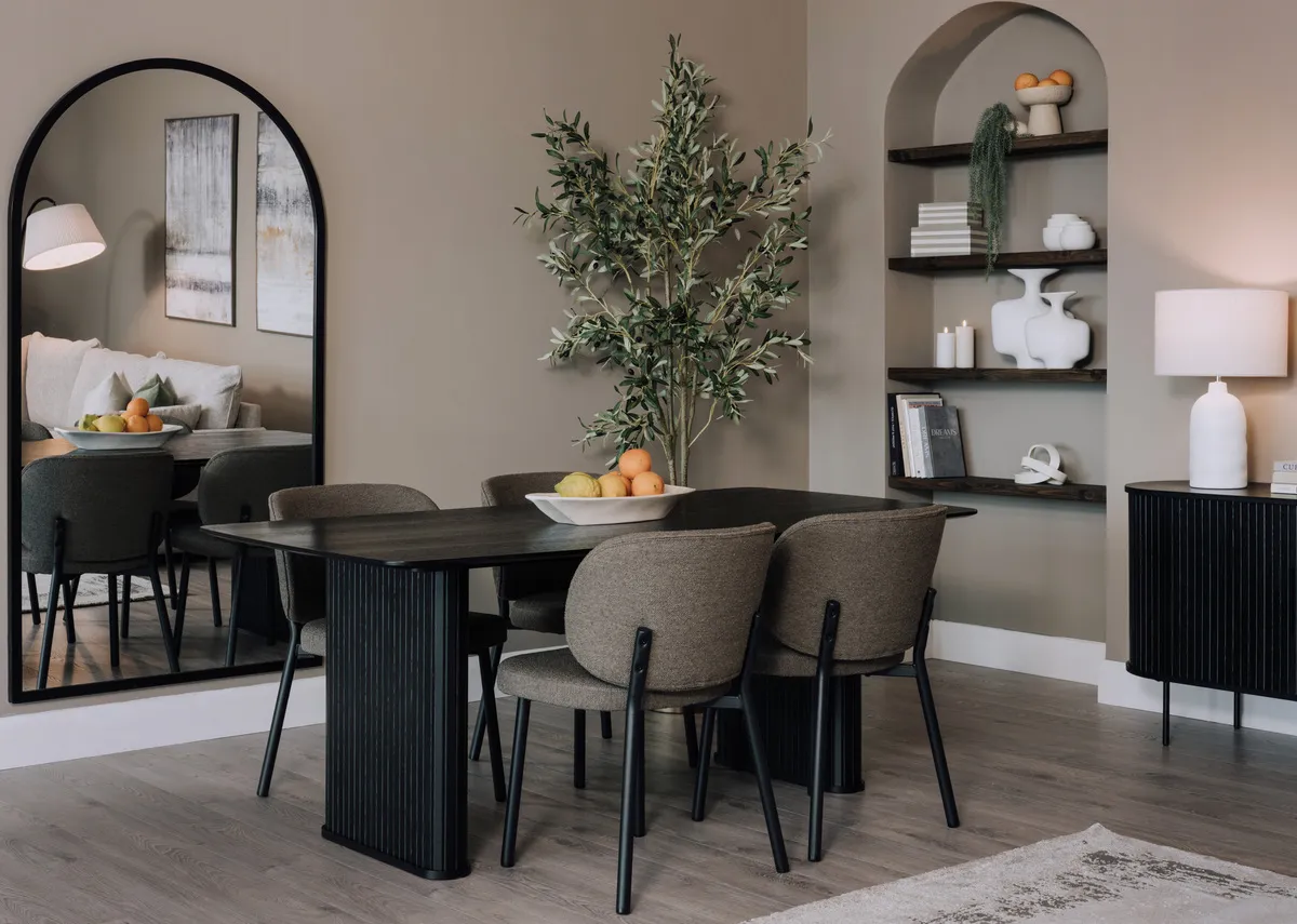A lifestyle image of the Nola dining table with Swan dining chairs and Chrisley mirror.