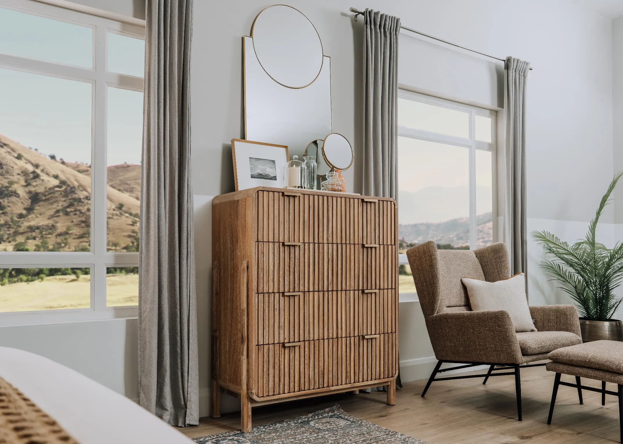 A lifestyle image of the Milo Tallboy dresser with Calista mirror and Boston chair with Footstool.