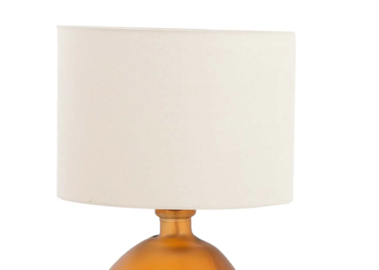 A round orange glass table lamp with off white shade fro EZ livings Alabama range. Closeup of drum shade