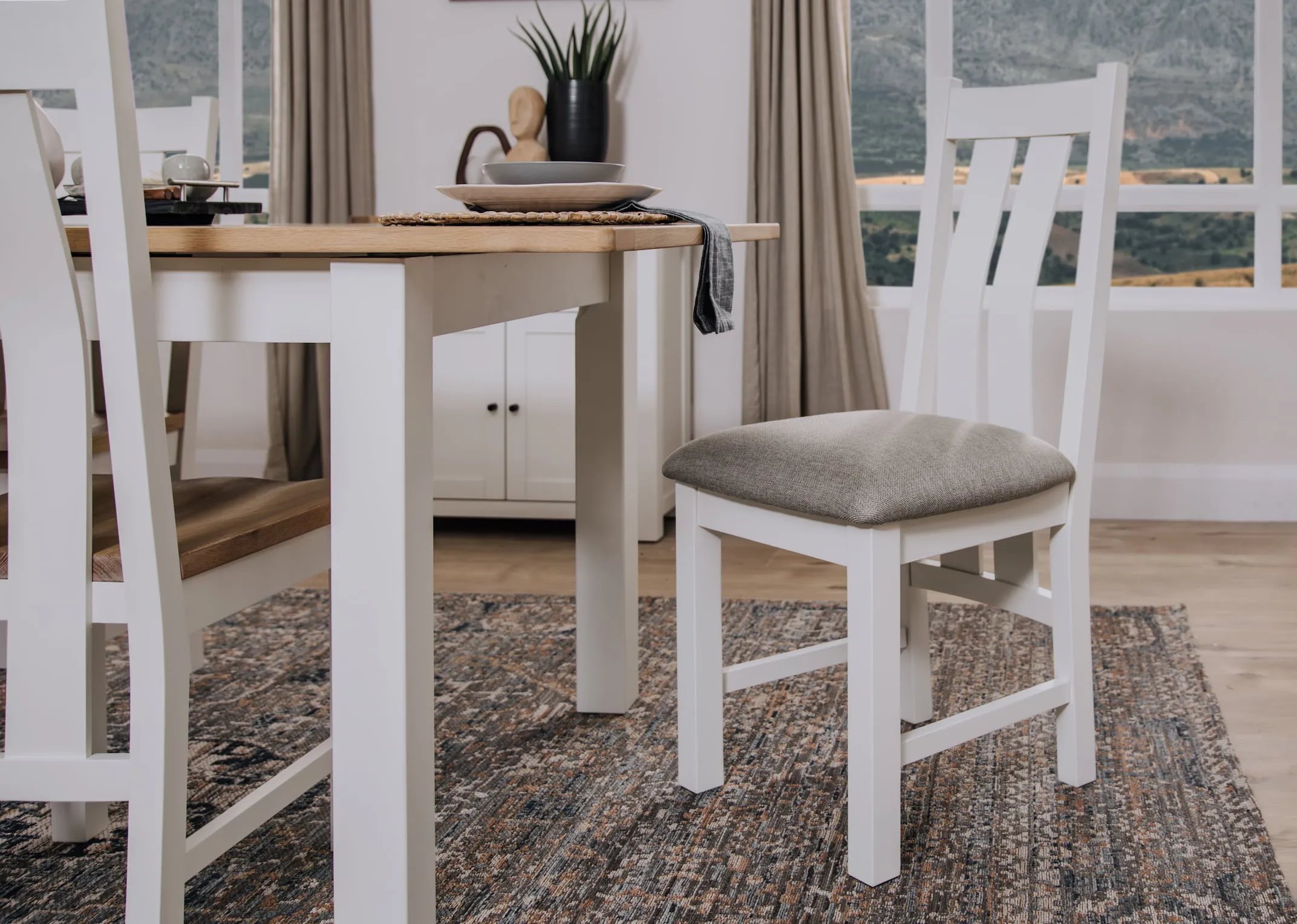 A lifestyle image of the Barleycove dining chair with fabric seat wth Dining table and sideboard.