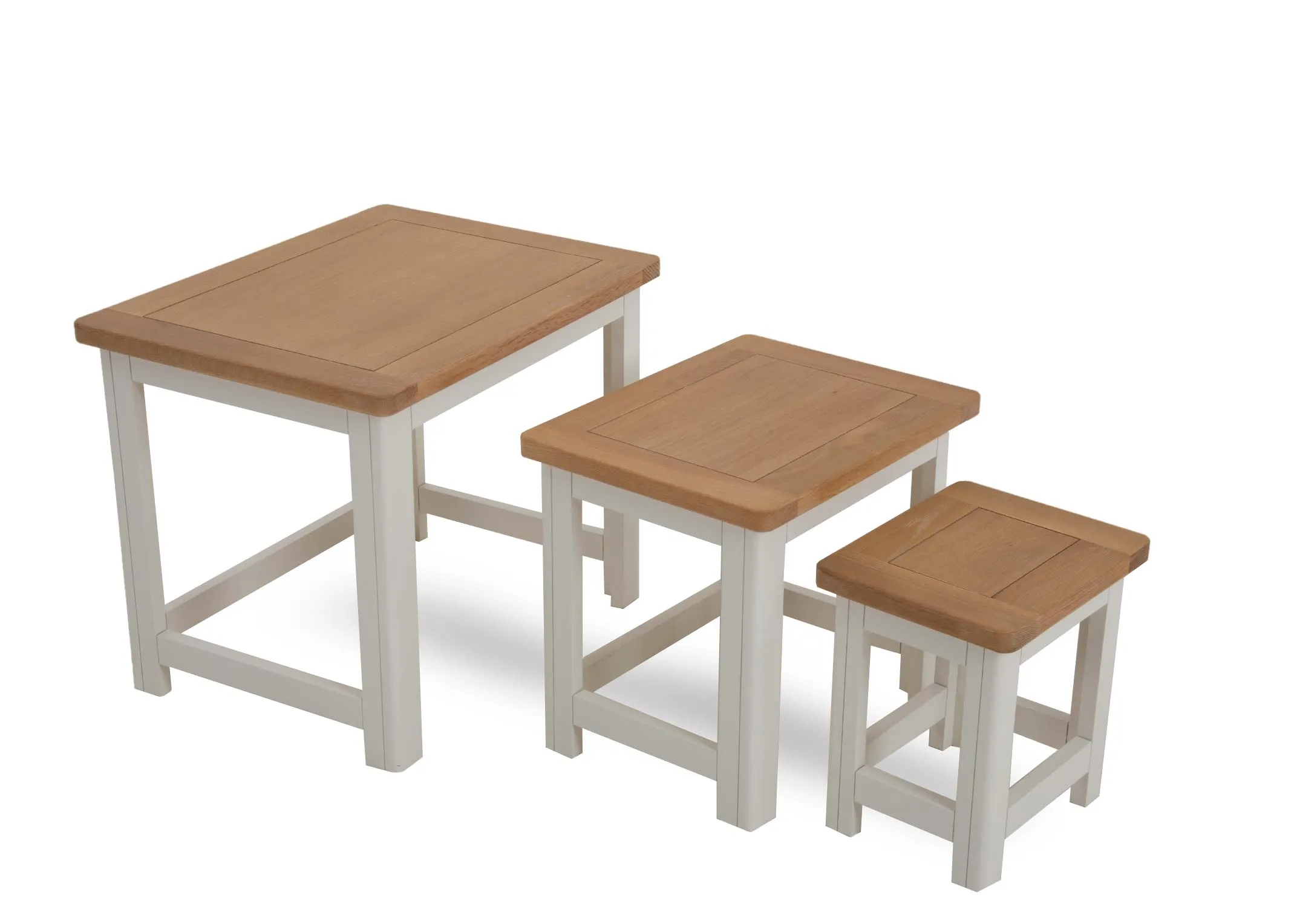 A nest of 3 tables from EZ Livings Barleycove range. Angled view of white legs & oak table top.