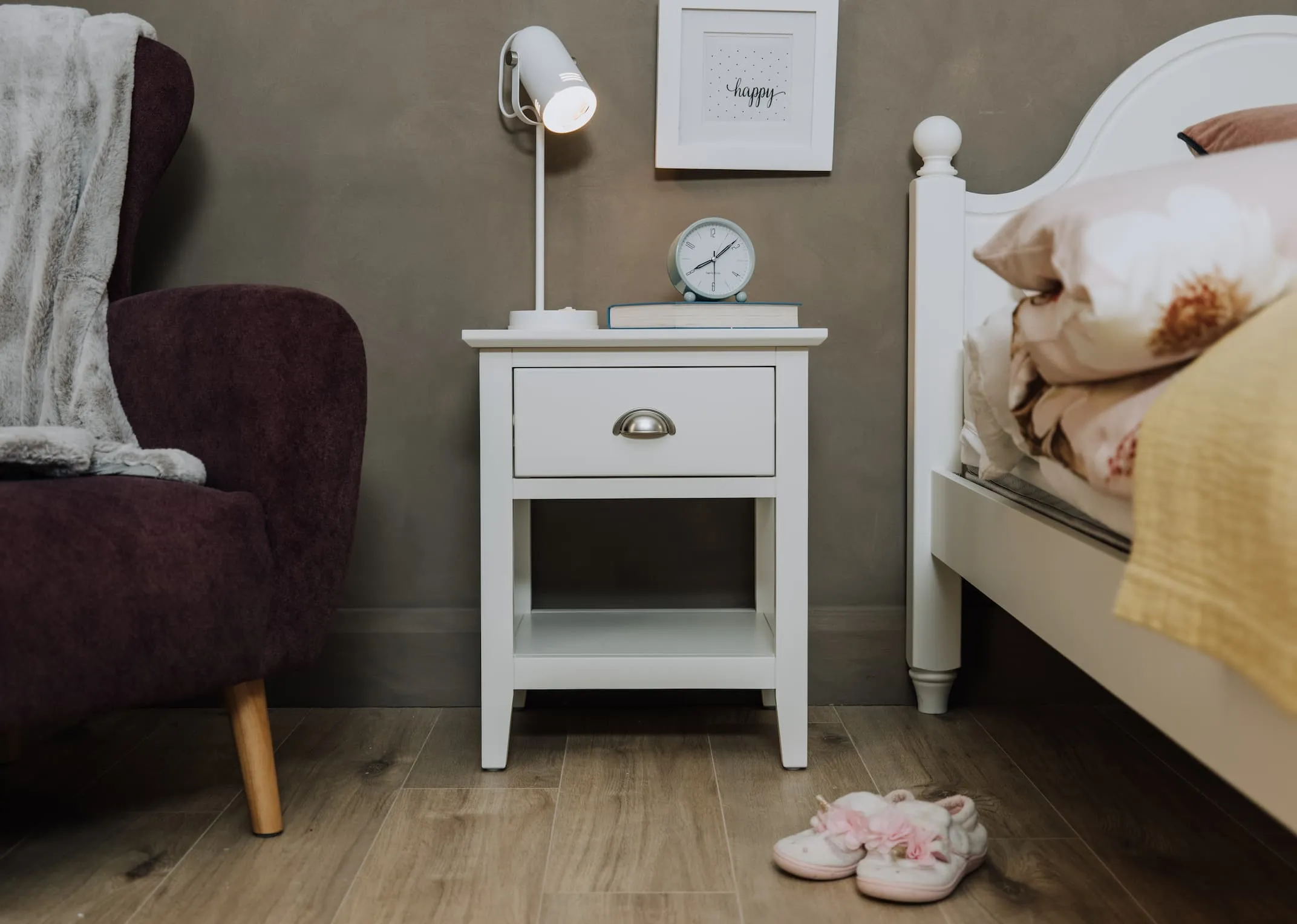 A lifestyle image of the Maine locker with husk table lamp and a clock.