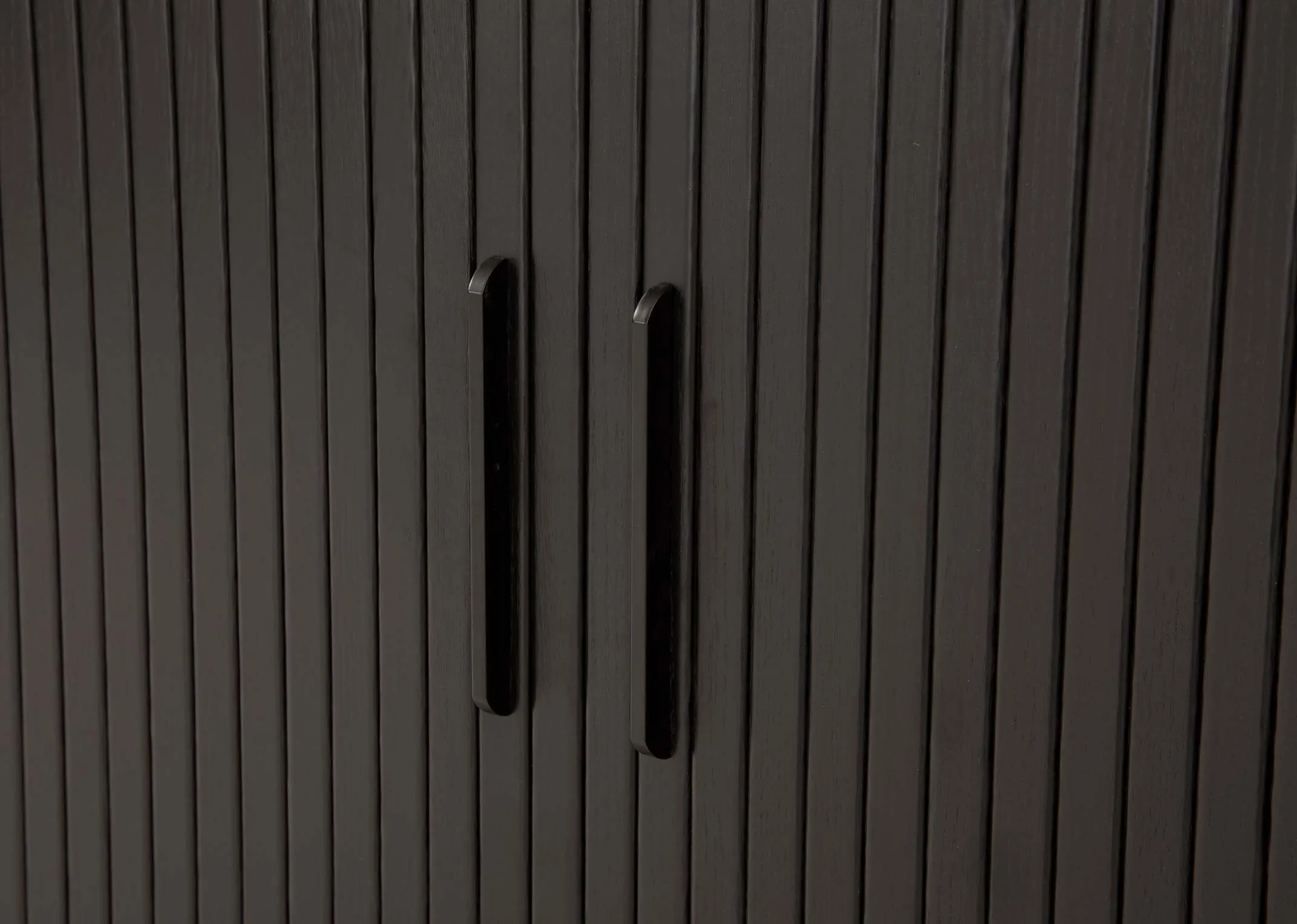 A black oak sideboard with a slatted tambour double door from EZ Livings Nola range. Closeup of textured worktop