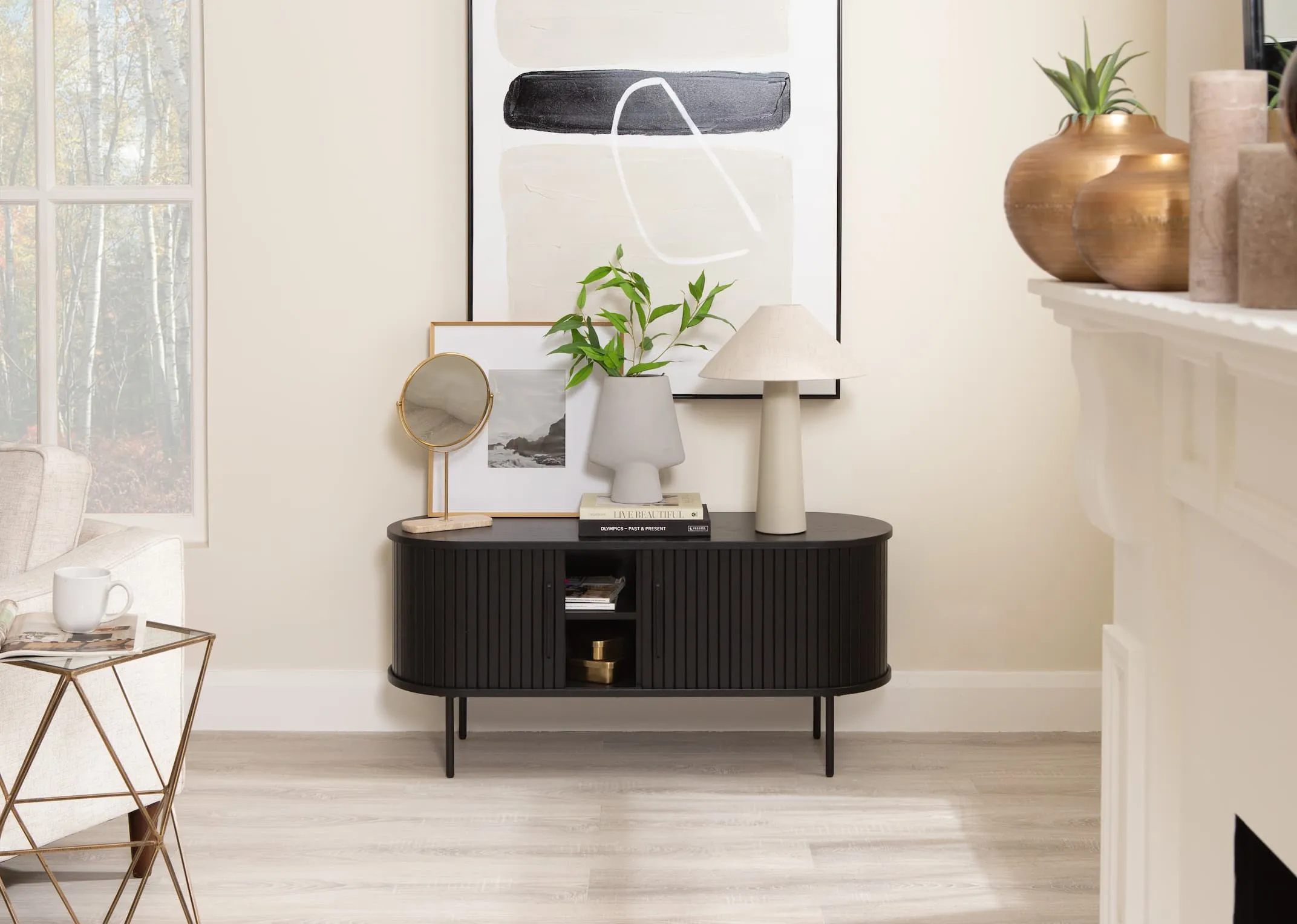 A lifestyle image of the Nola black tv unit open with Daisy lamp and riesco mirror and Ciara vase with Large black and white canvas.