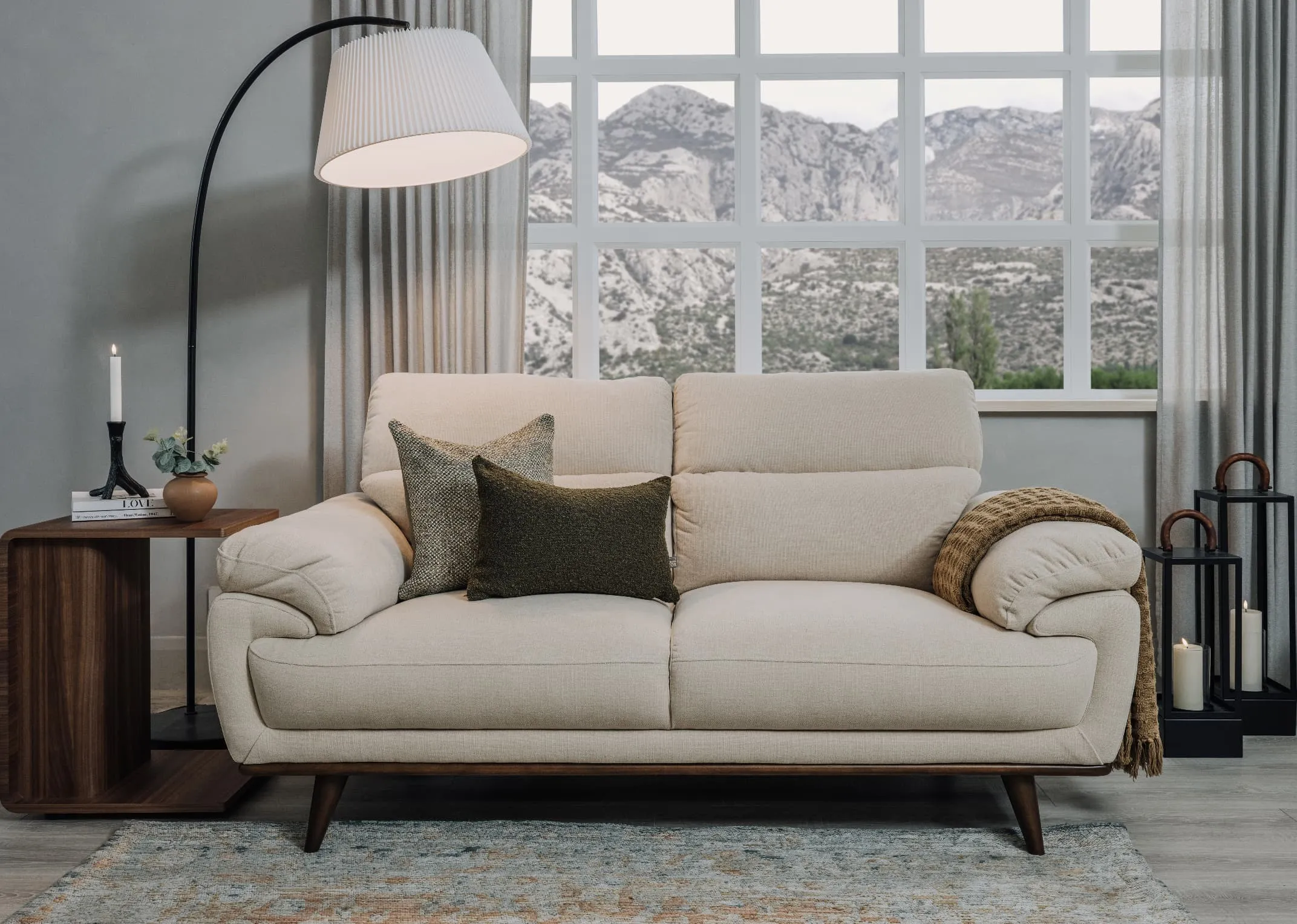 A lifestyle image of the Pippa cream sofa with Uptown side table and Arc floor lamp.