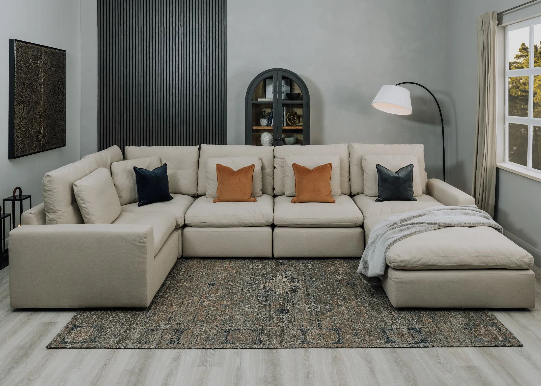 A lifestyle image of the Cozy large sofa with ottoman and Juliet Cabinet.