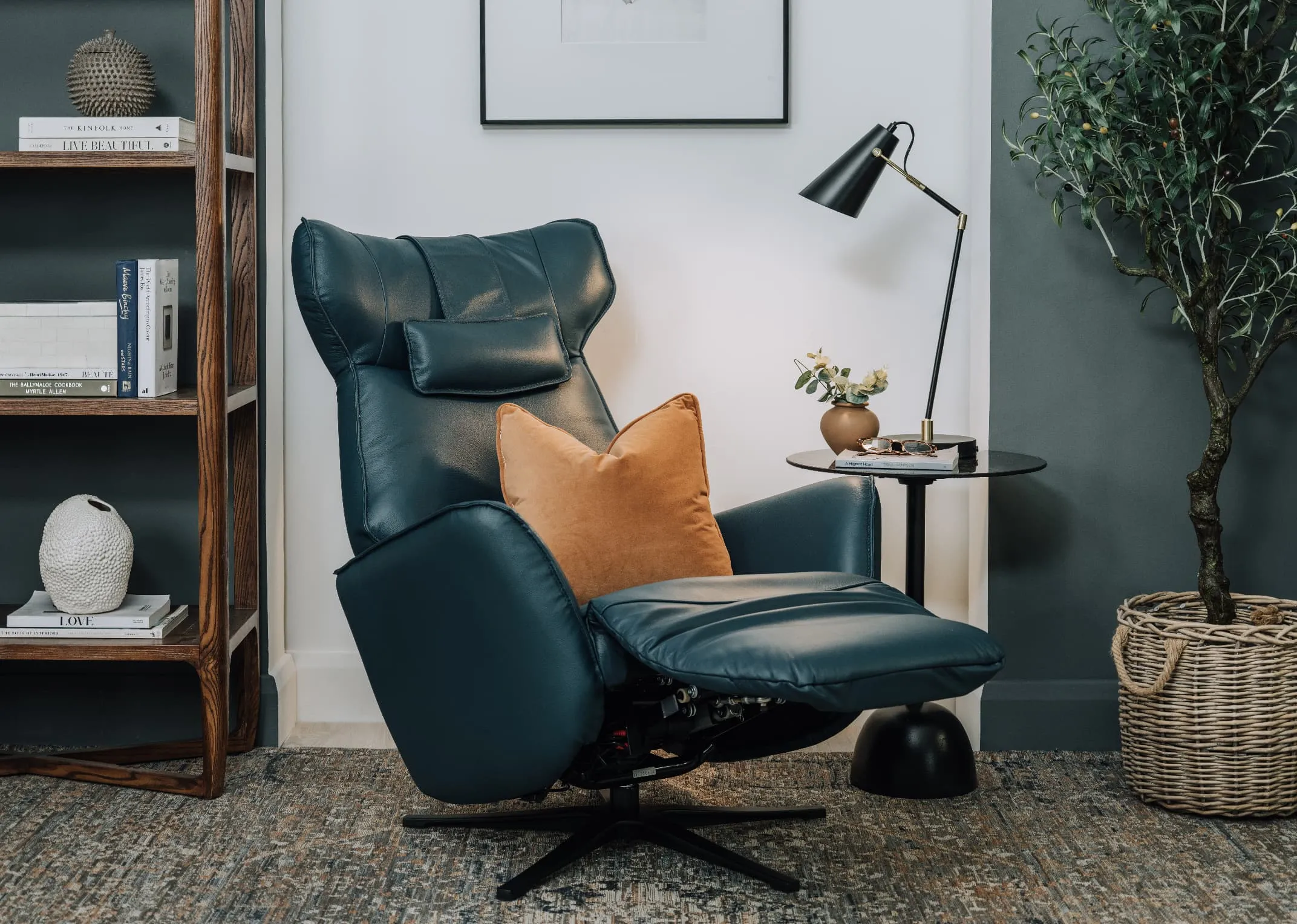 A lifestyle image of the Carrie teal recliner out with massimo table with gold cushion.