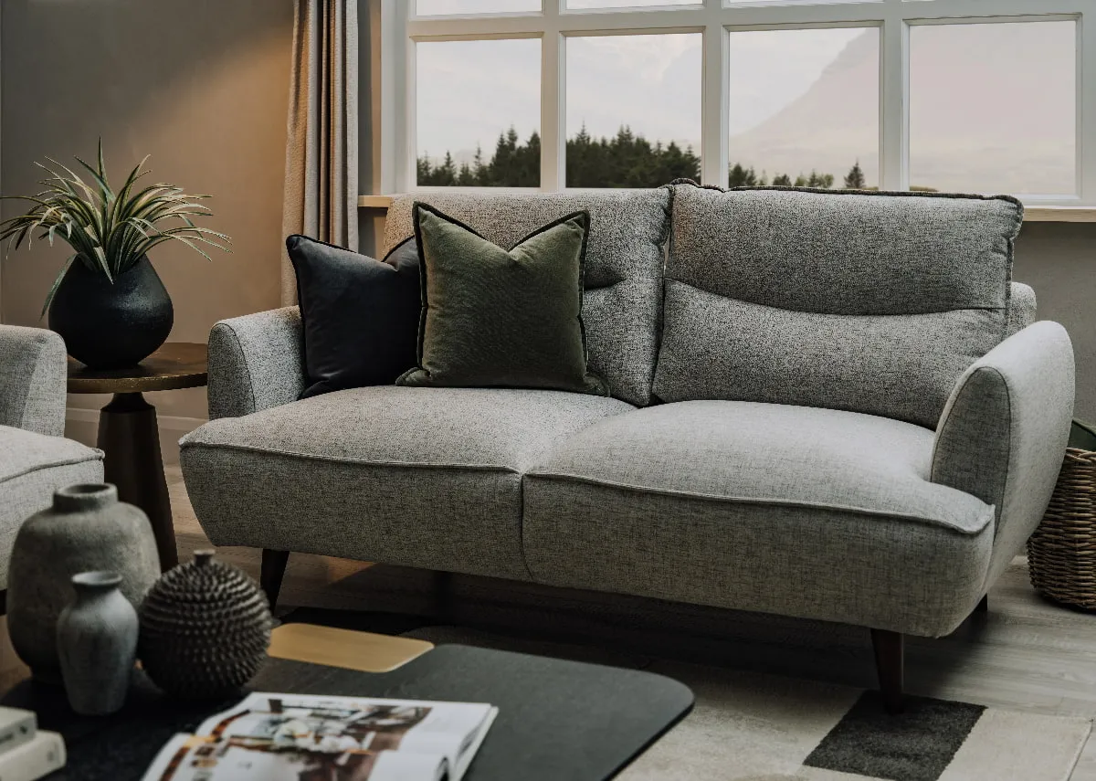 A lifestyle image of the Marlyn silver sofa with echo coffee table and a selection of vases.