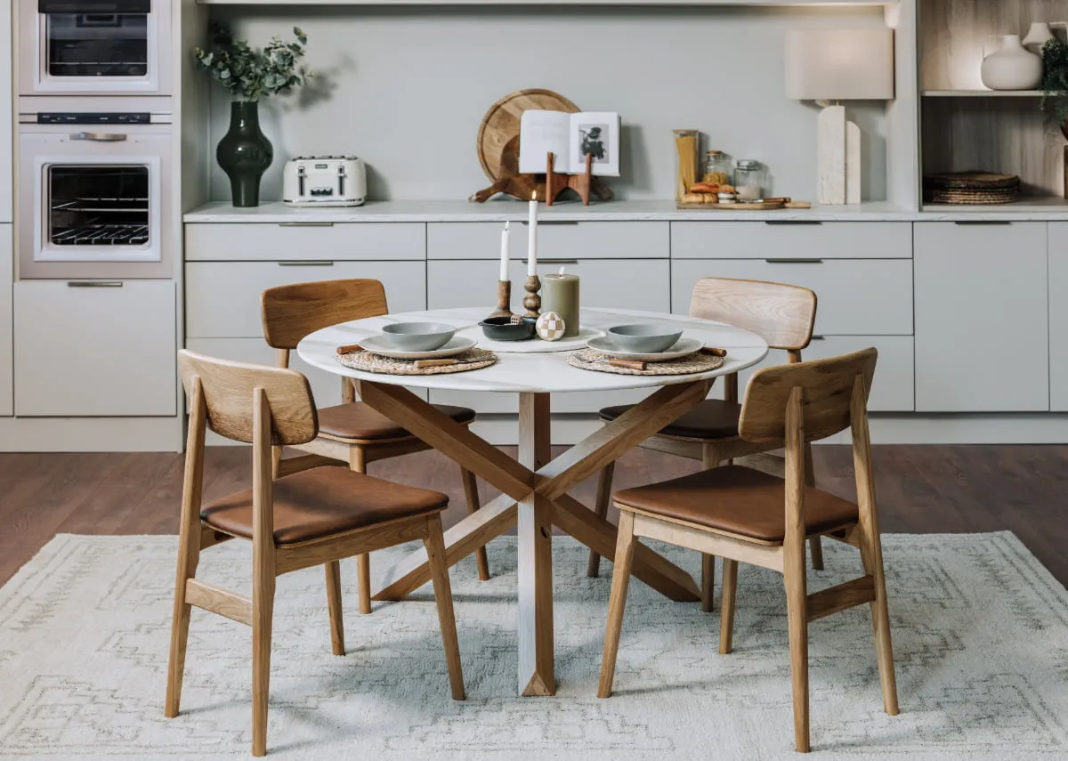 A lifetsyle image of the Ravello round table with matching chairs in a white kitchen setting