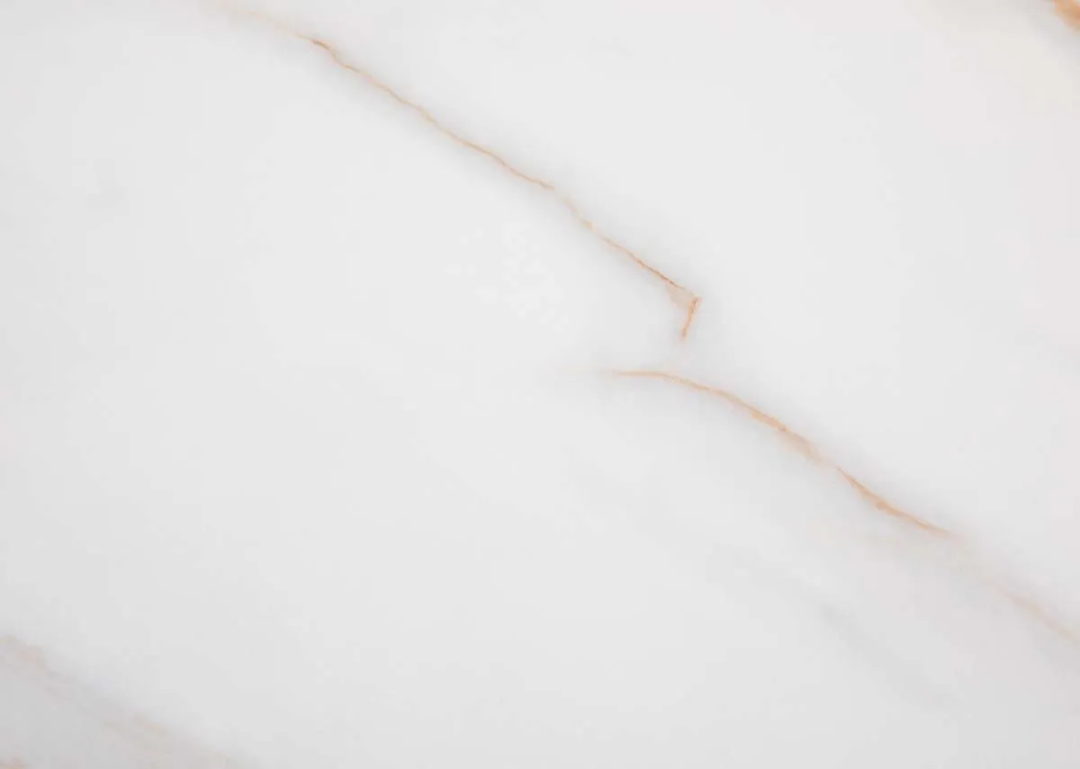 A round melamine top dining table with oak legs from EZ Livings Ravello range. Closeup of matt melam