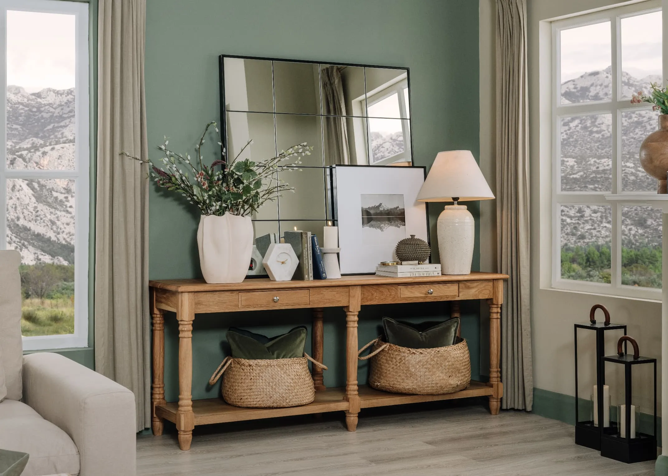 A lifestyle image of the Iona Console Table with Farley mirror and a selection of vases and lamps with 2 baskets on lower shelves.
