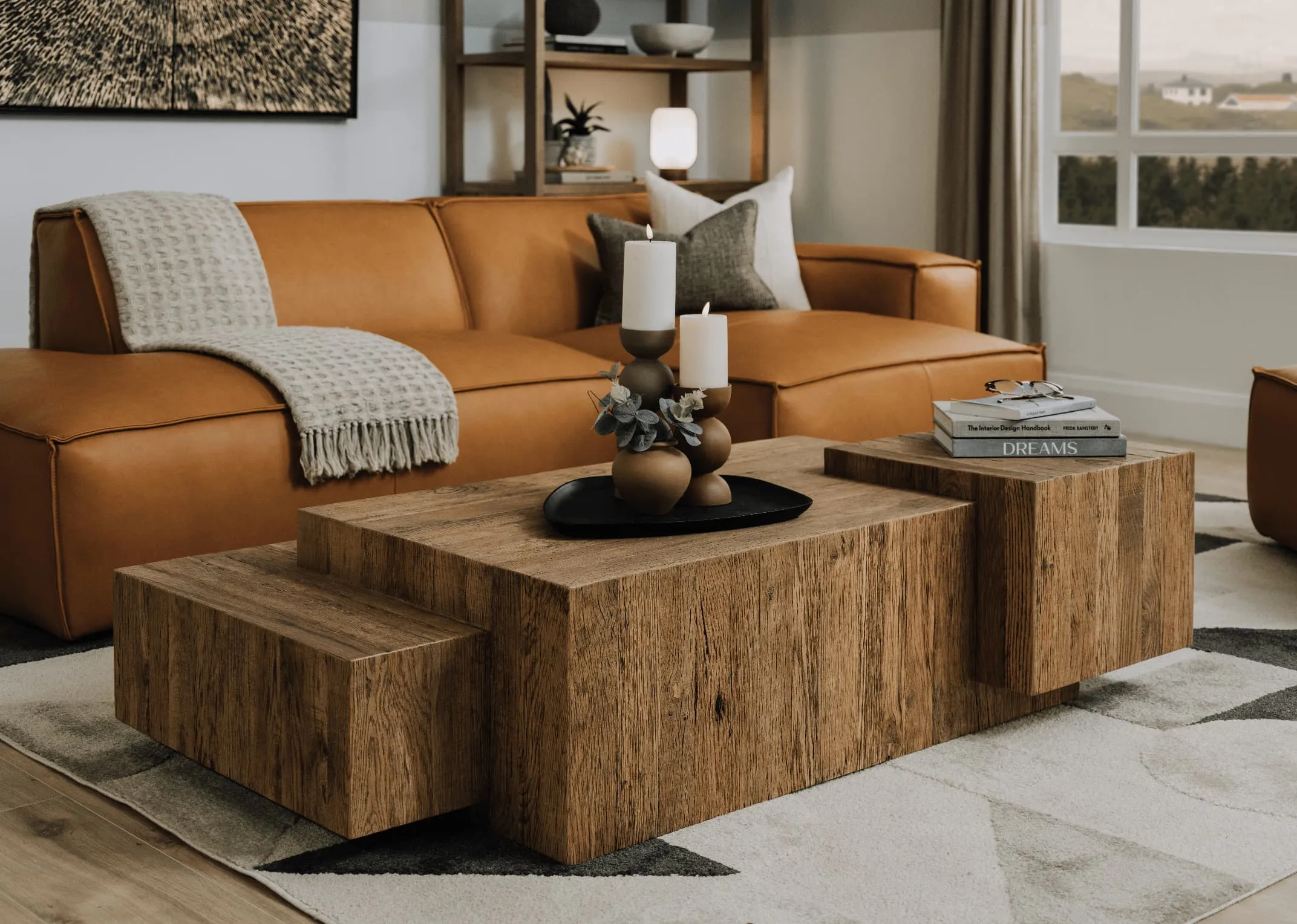 A lifestyle image of the Jayden leather sofa with Nova coffee table with black plate and candle holders.