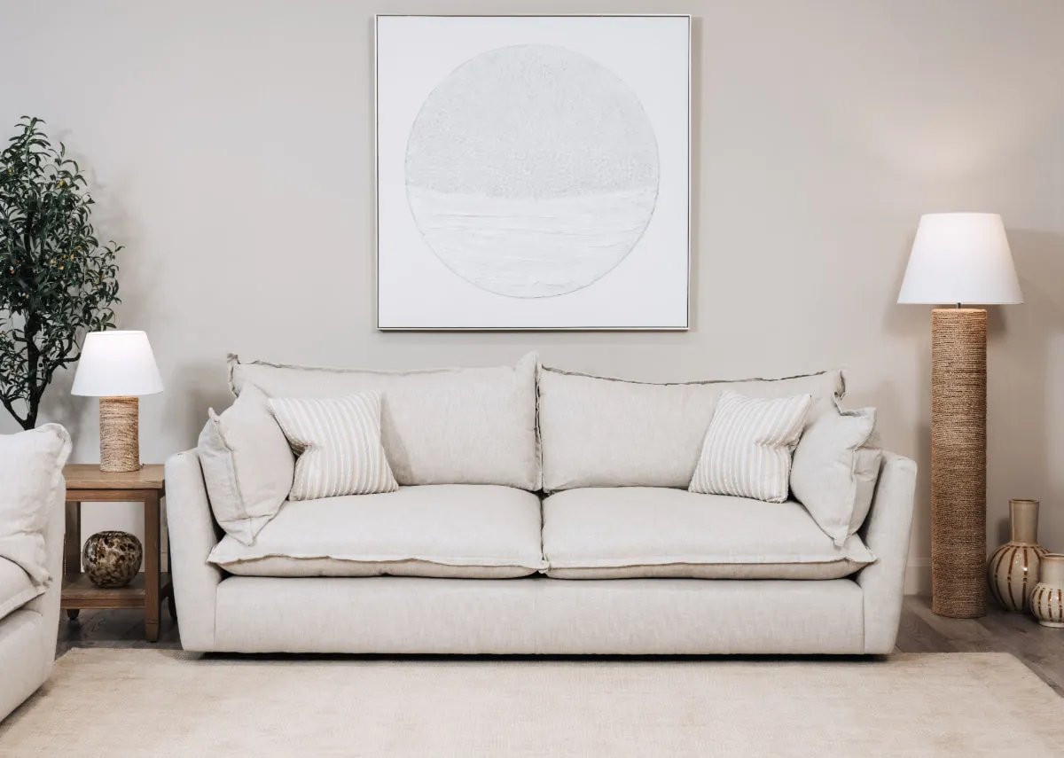 A lifestyle image of the Pathway picture over the Tara sofa with dawn side table and melody lamps.