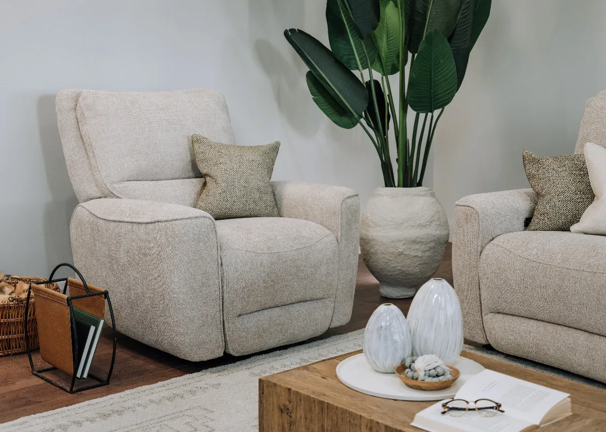 A lifestyle image of the Ashbrook Power recliner in fixed mode with the Ashbrook sofa and nova table