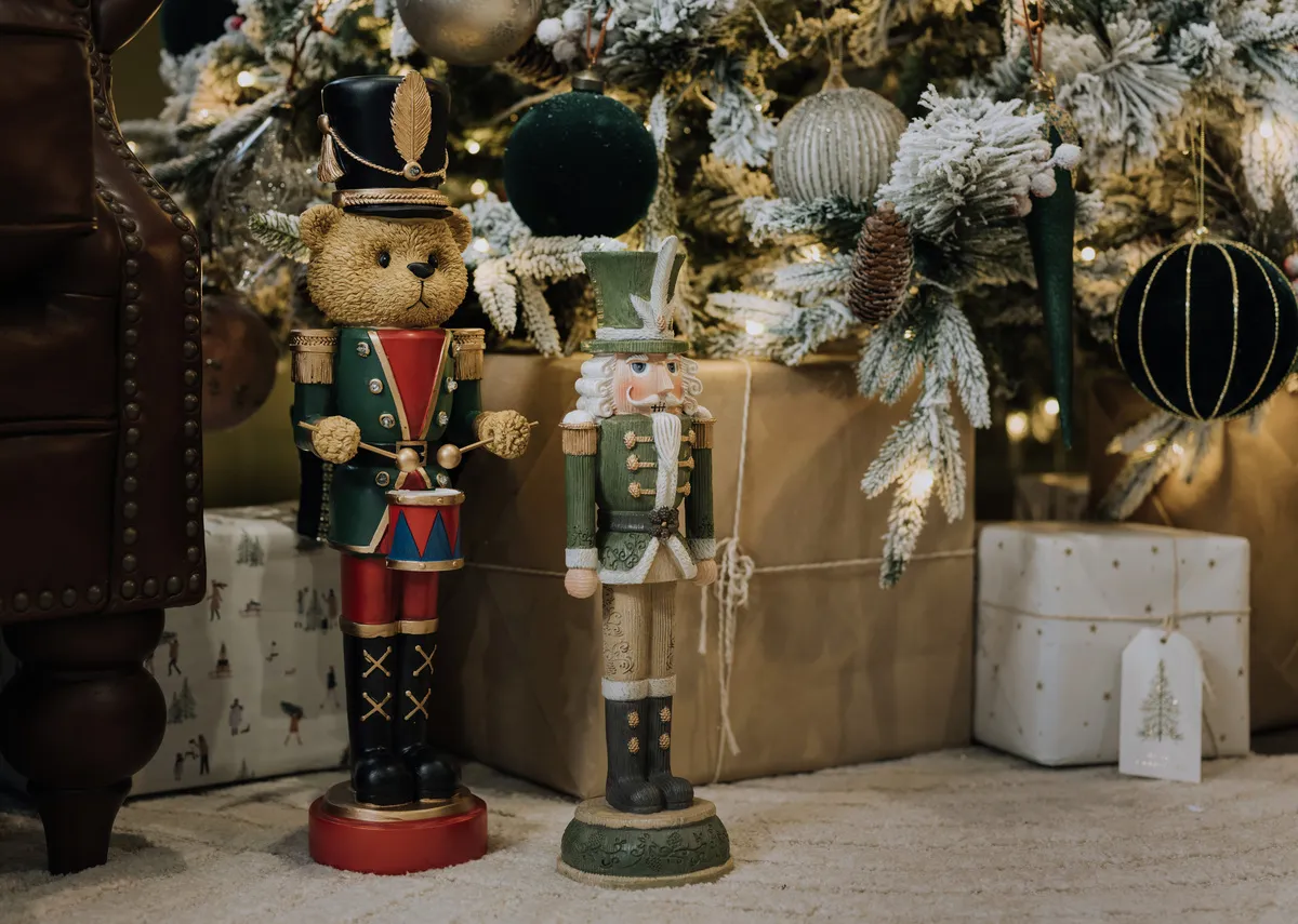 A lifestyle image of the Alister nutcracker with Teddy Nutcracer at the base of a tree.