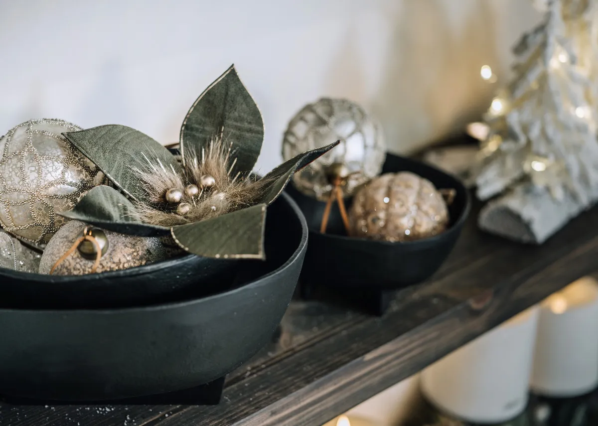 A lifestyle image of the Green flower with christmas carol baubles in a bowl.