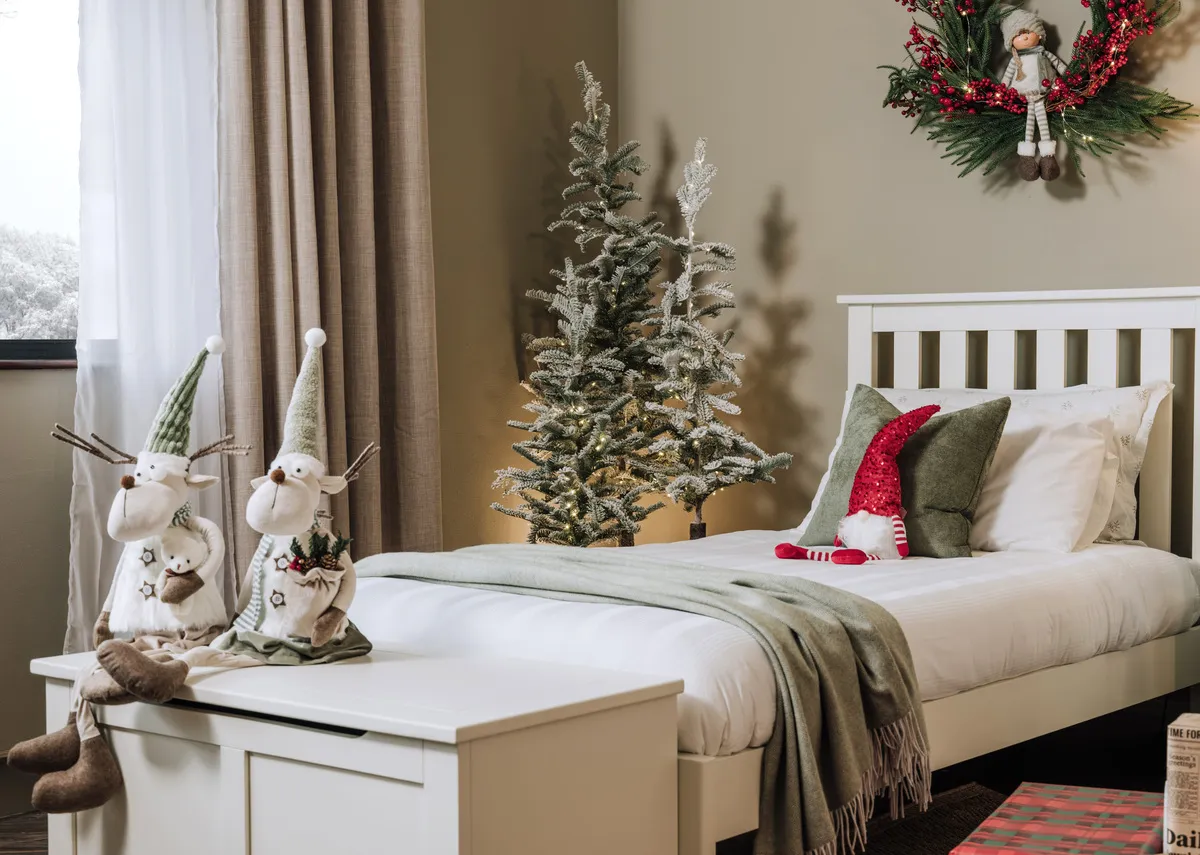 A lifestyle image of the Atlas bed with Alder trees and Reindeer toys on blanket box.