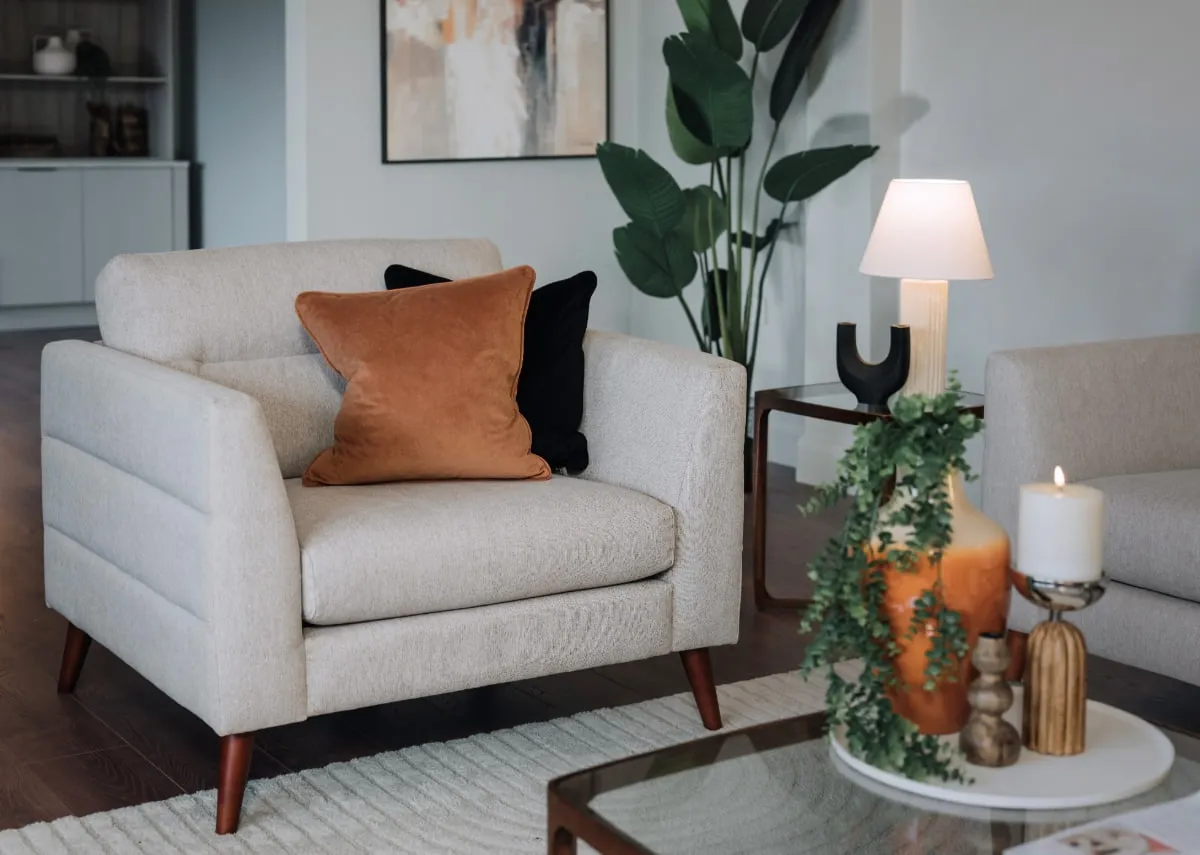 A lifestyle image of the Presley Beige Armchair with cameo tables from EZ Living with cream lamp