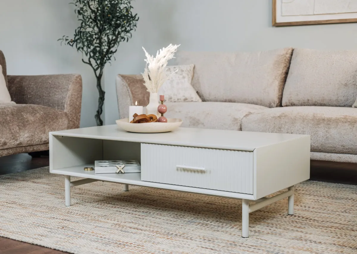 A lifestyle image of the Palma coffee table with dish with candles and Boutique sofa.