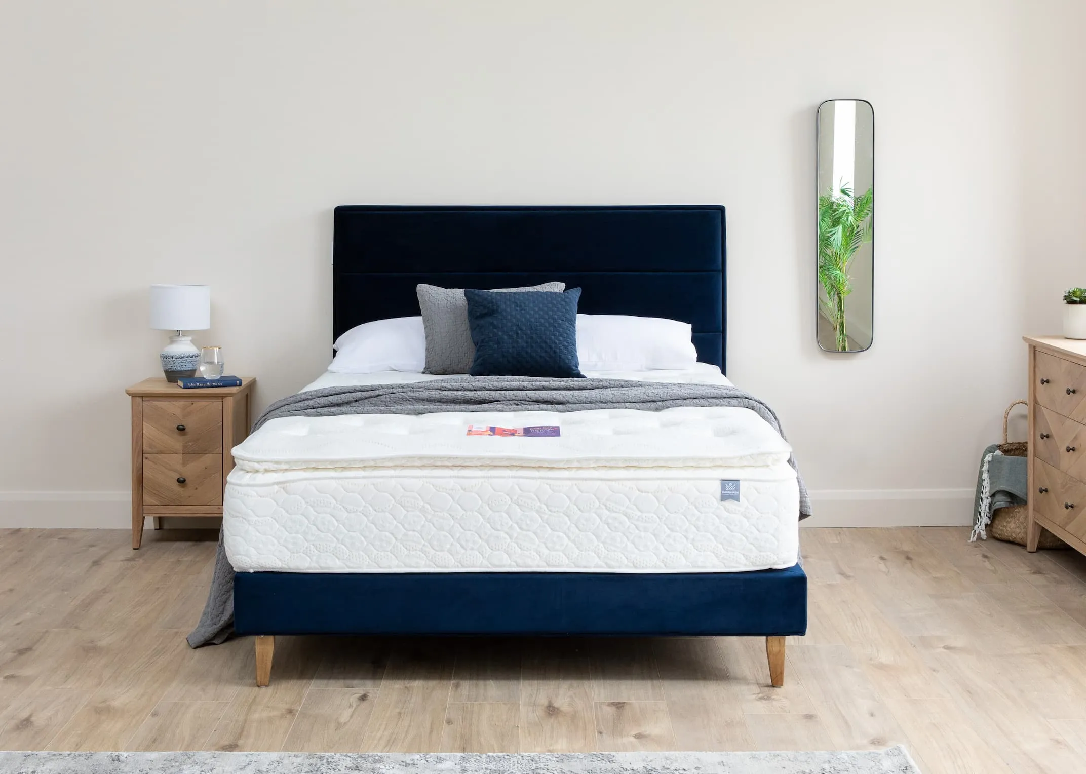 A lifestyle image of the Ebony Blue Velvet Bed base & headboard with chevron chest & Locker.