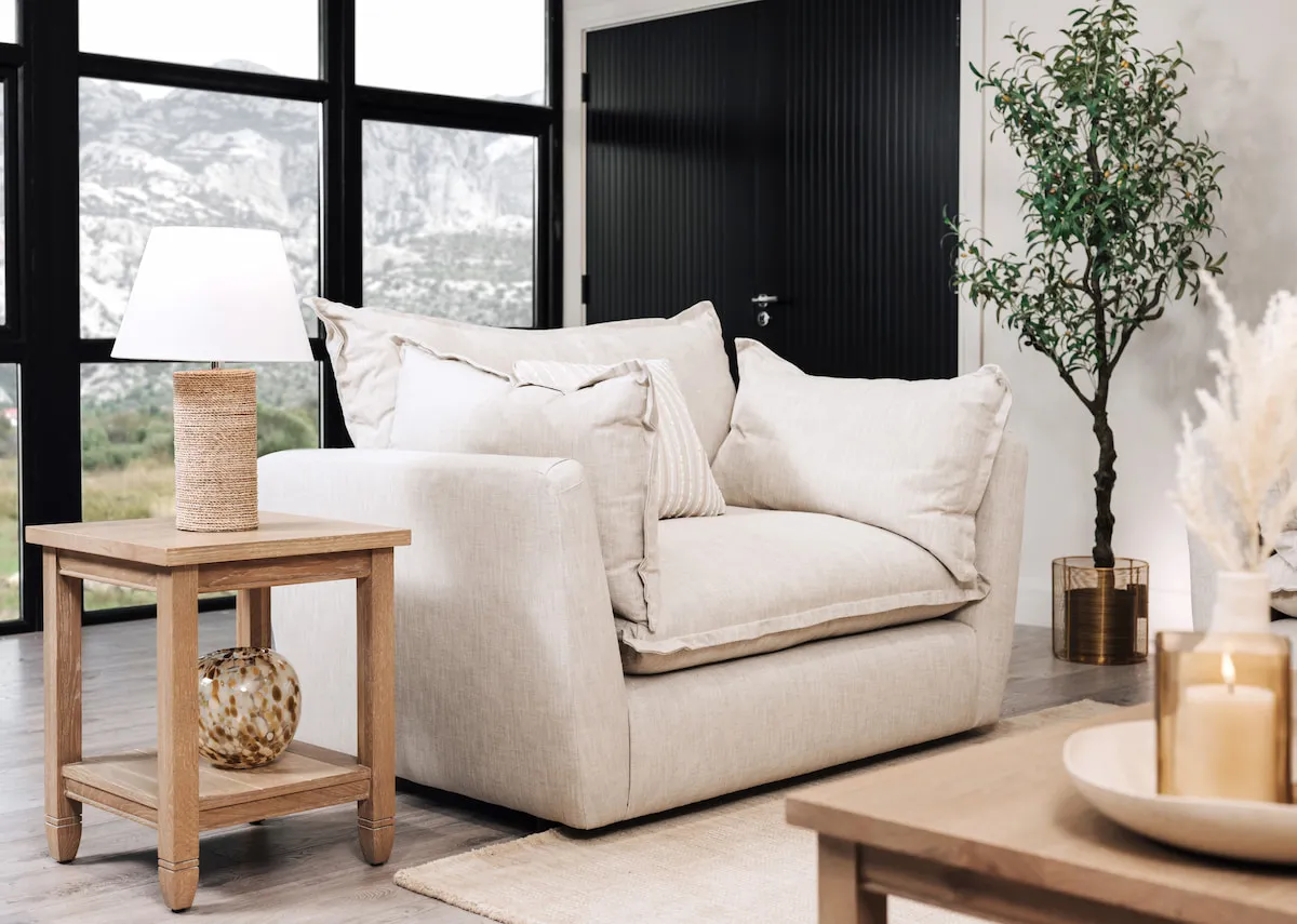 A lifestyle image of the Pathway picture over the Tara sofa with dawn side table and melody lamps.