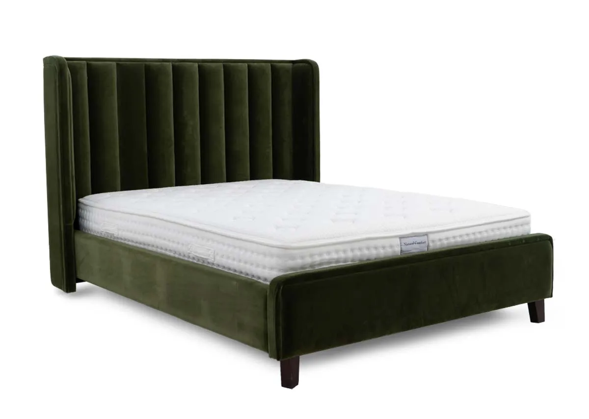 An olive green fabric bedframe with high winged headboard from EZ Liings Lowe range. Angled view of walnut feet.