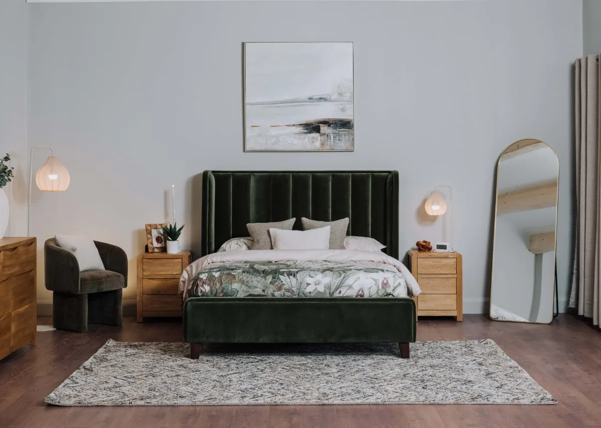 A lifestyle image of the Lowe green bedframe with iris locker and vance mirror with San Jose rug