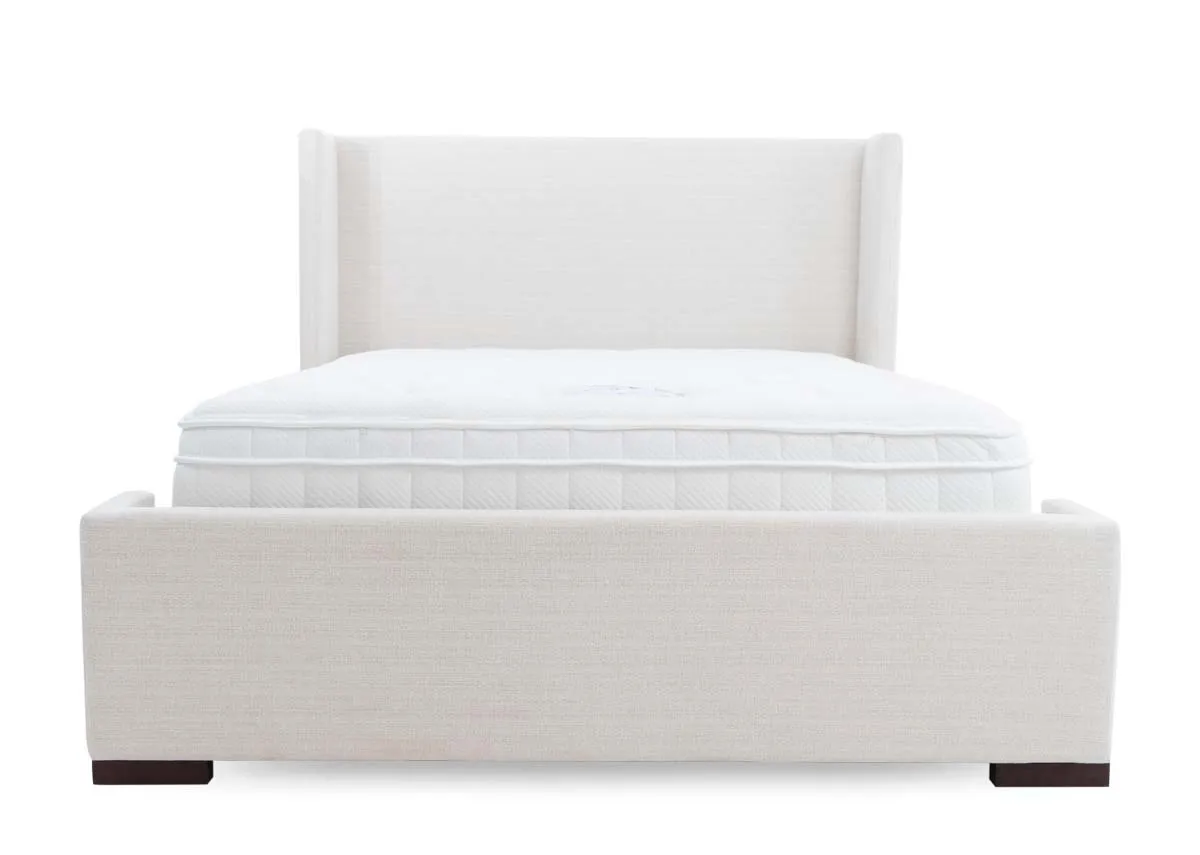 A beige fabric bed frame with high winged headboard from EZ Livings Quay west range. View from end of high footboard