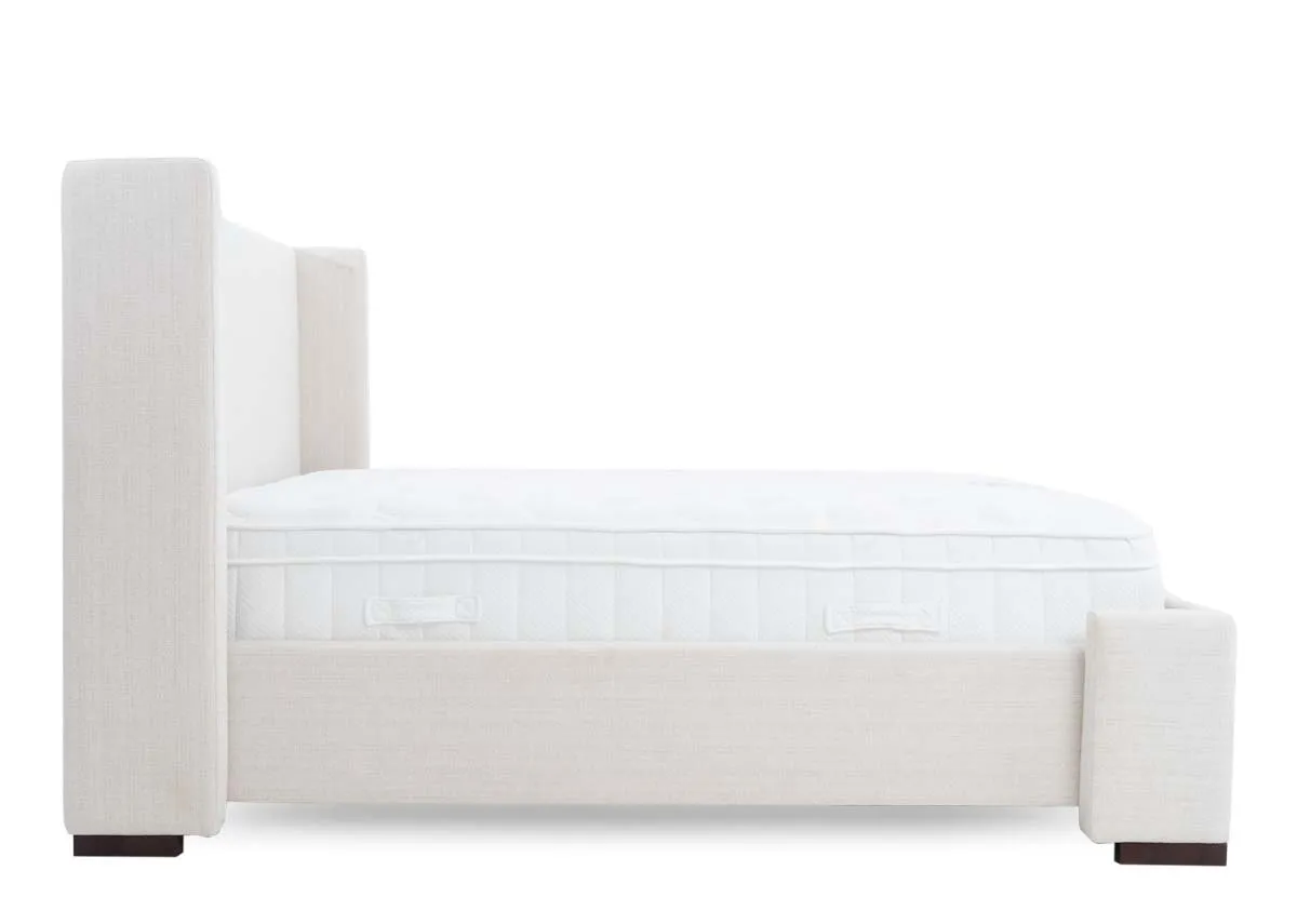 A beige fabric bed frame with high winged headboard from EZ Livings Quay west range. Side view of covered high frame