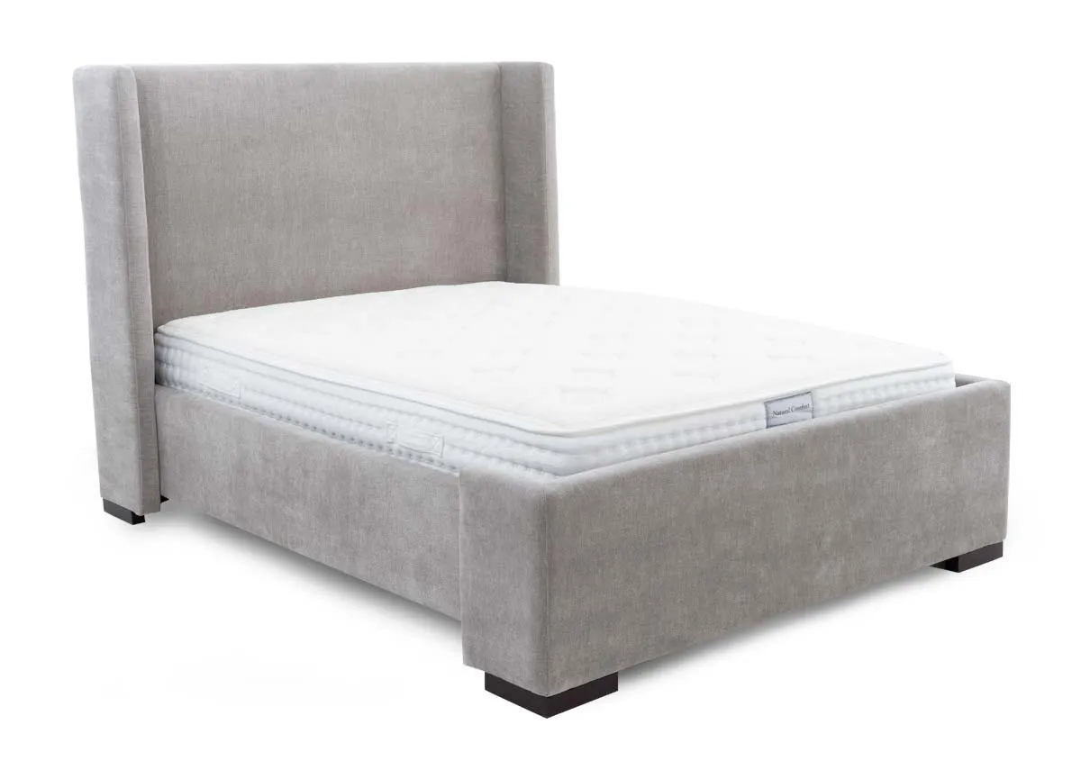 A grey fabric bed frame with high winged headboard from EZ Livings Quay west range. Angled view of matttress inserted not included.
