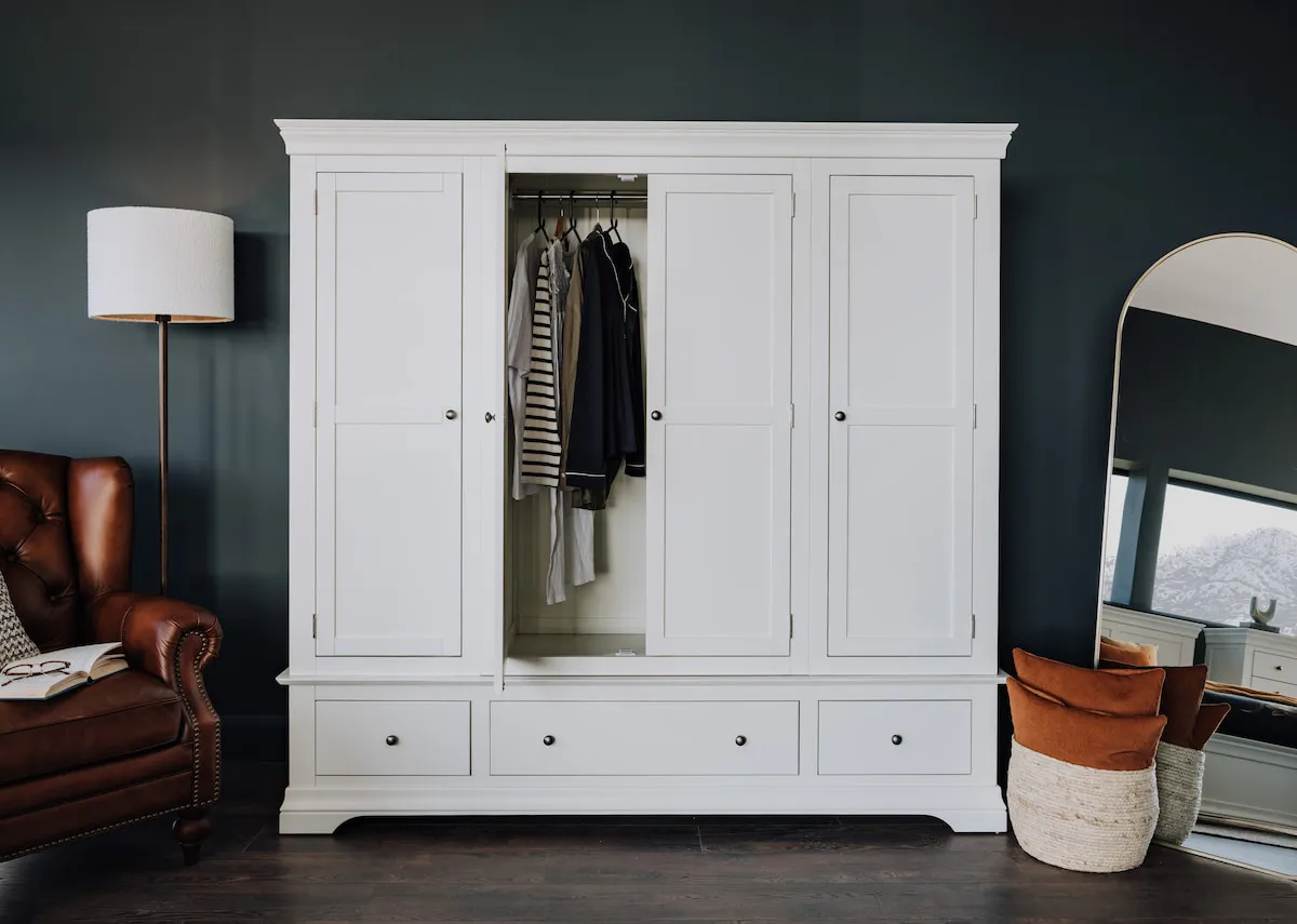 A lifestyle image of the Dove wardrobe with middle door open showing hanging space .