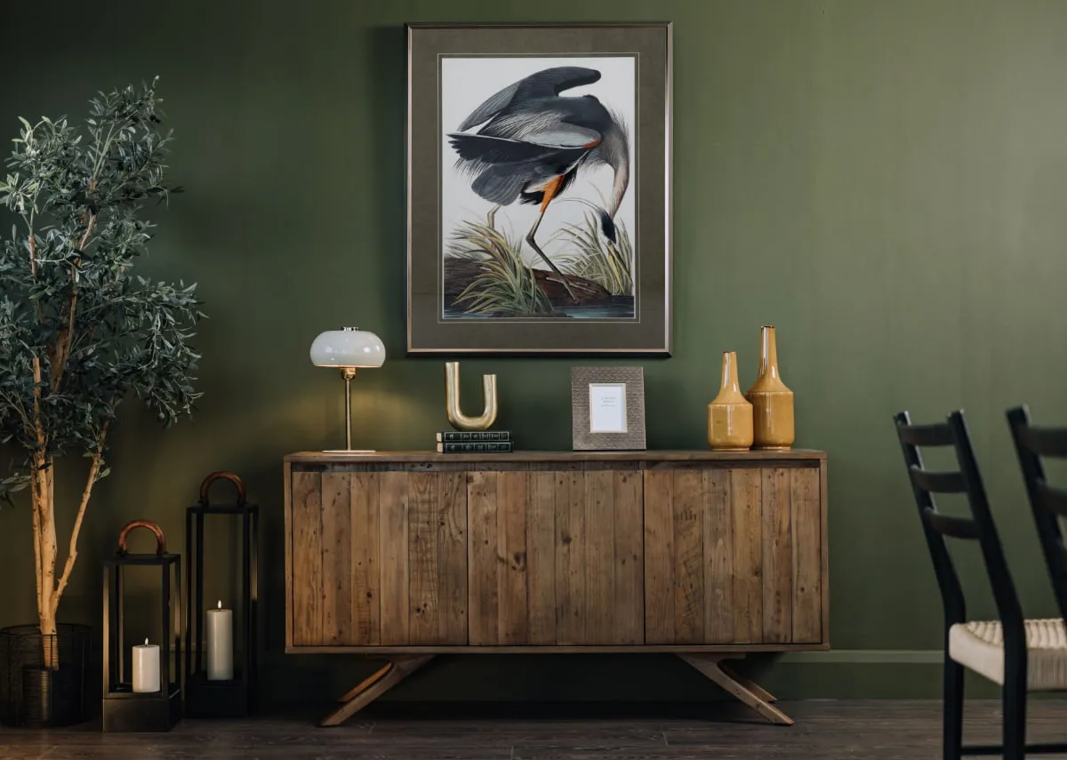 A lifestyle image of the Cozy Corner Sofa with Gold Coast tables and Blue Heron print