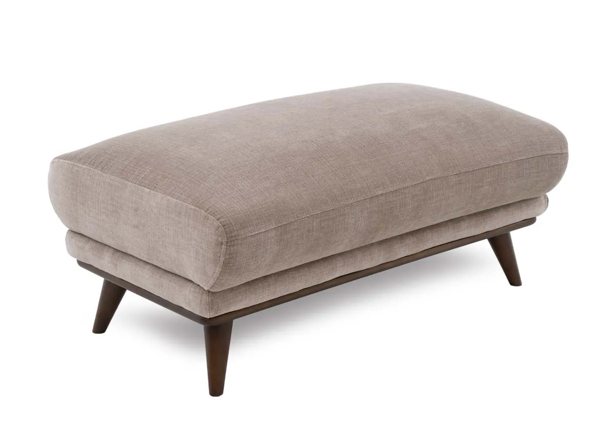 A beige large footstool from EZ Livings Pippa Range. Angled view of plump cushion seat and dark wood legs.