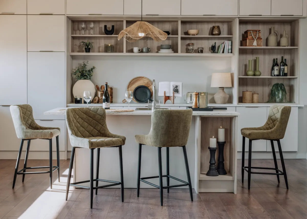 A lifestyle image of the Ottowa Green bar stools with a neutral cream kitchen island.