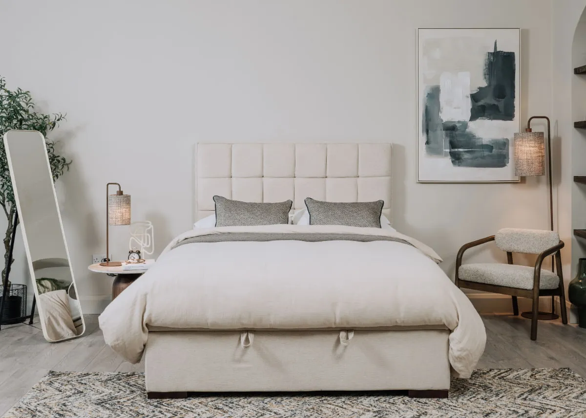 A lifestyle image of the Sadie ottoman with blue marine canvas and Taina mirror