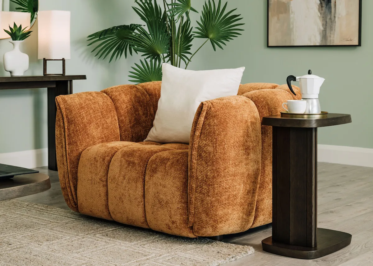 A lifestyle image of the Matera rust armchair with Rimini laptop table.