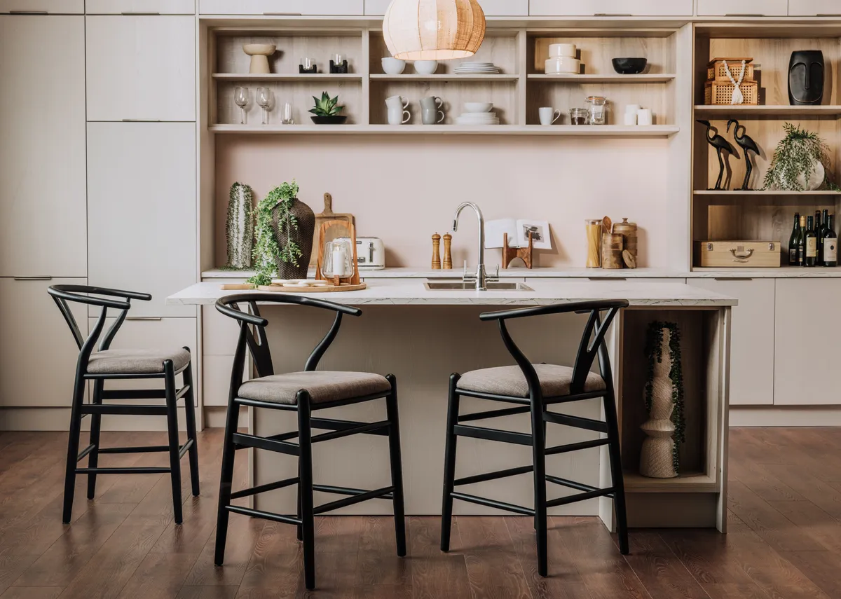 A lifestyle image of the Wishbone bar stool at a kitchen island