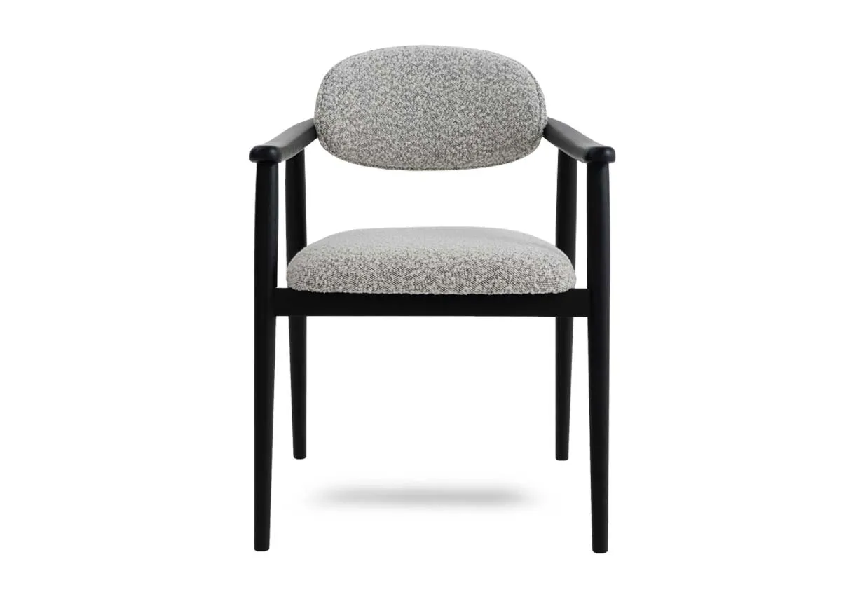 A black framed dining chair with grey boucle fabric from EZ Livings Rego range. Front view of oval seat rest.