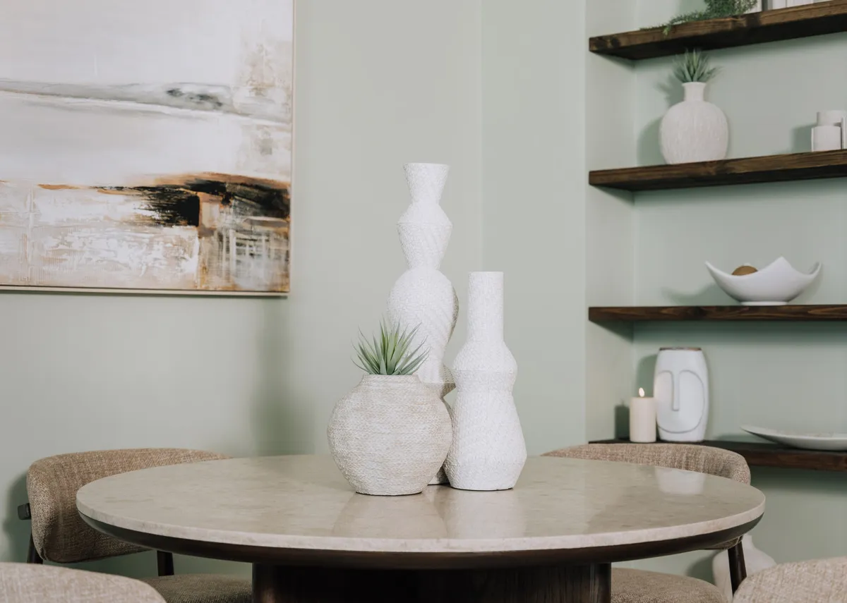A lifestyle image of the Dining table with a set of 3 jade vases in the centre