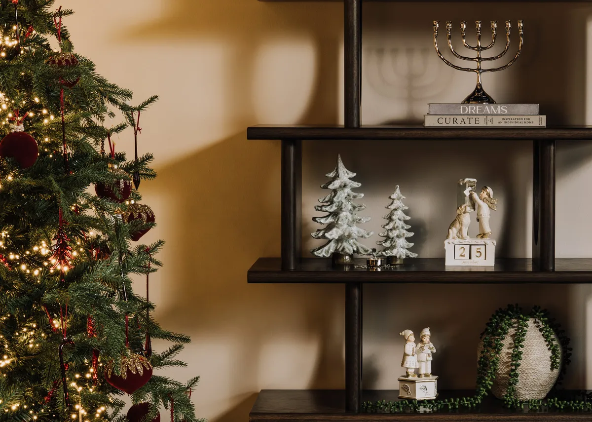 A lifestyle image of the Aspen tree with Flow display with Snow figurines including the Winter boy & Menorrah Candle holder