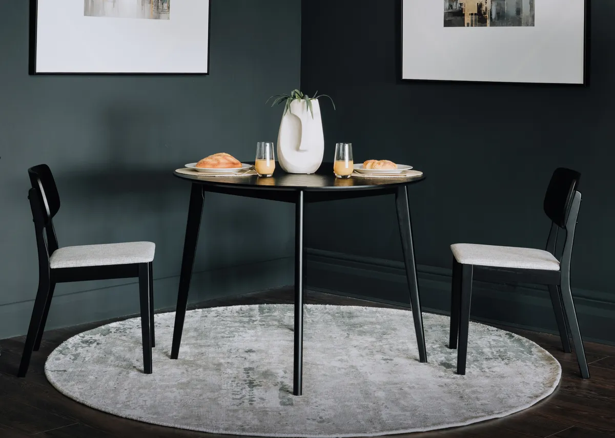 A lifestyle image of the Sonoma black dining chairs and dining table with the Elevate prints.
