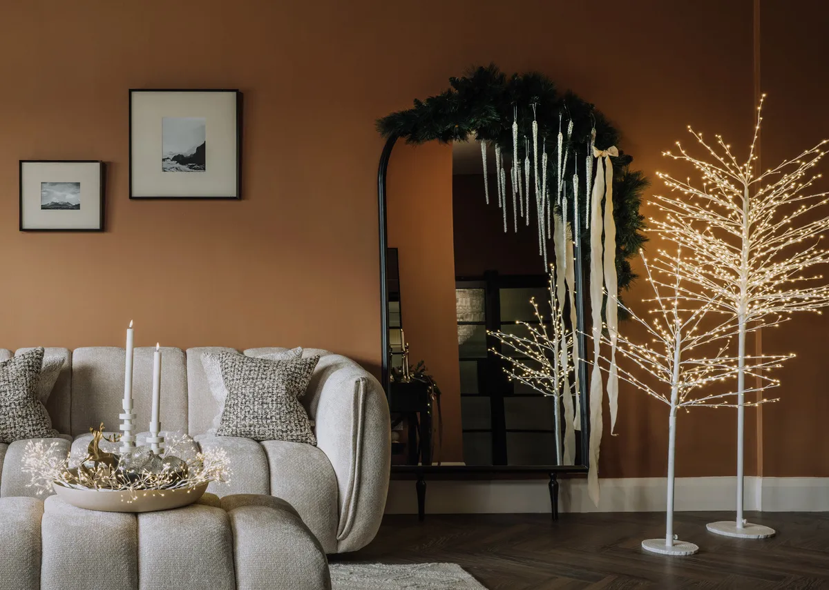 A lifestyle image of the Rudy tree with Kenzy mirror and Matera sofas