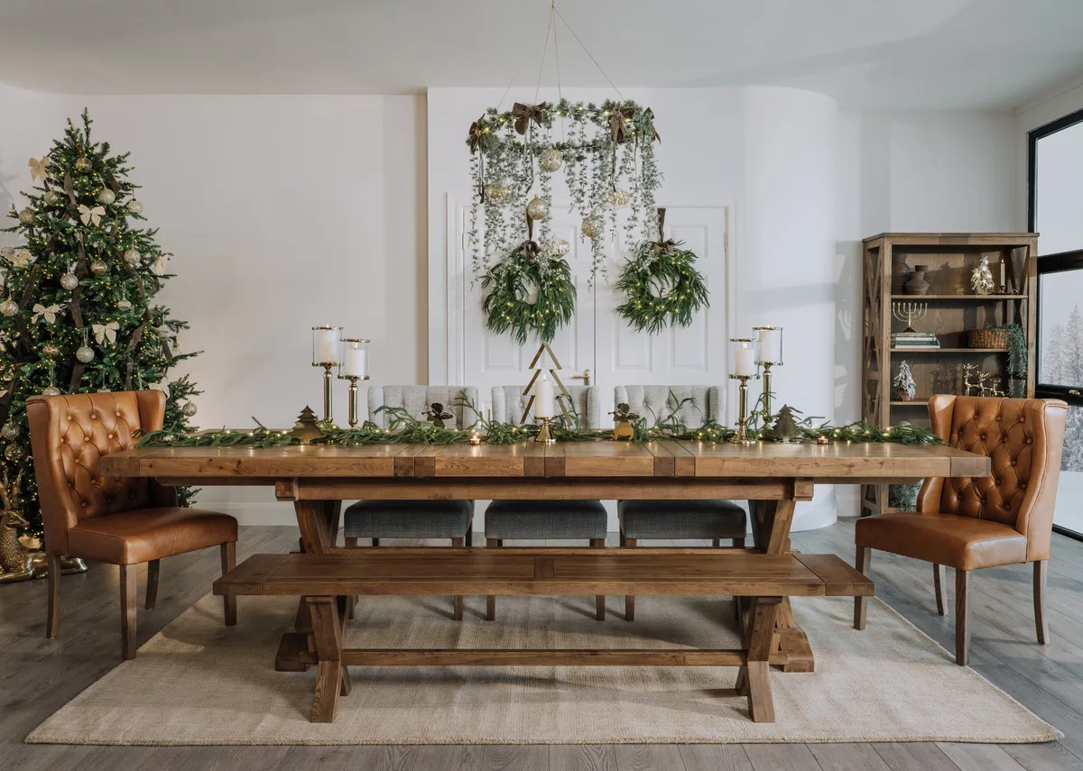 A lifestyle image of the Tommy leather dining chair with the Naxos dining table and bench with Christmas tree!